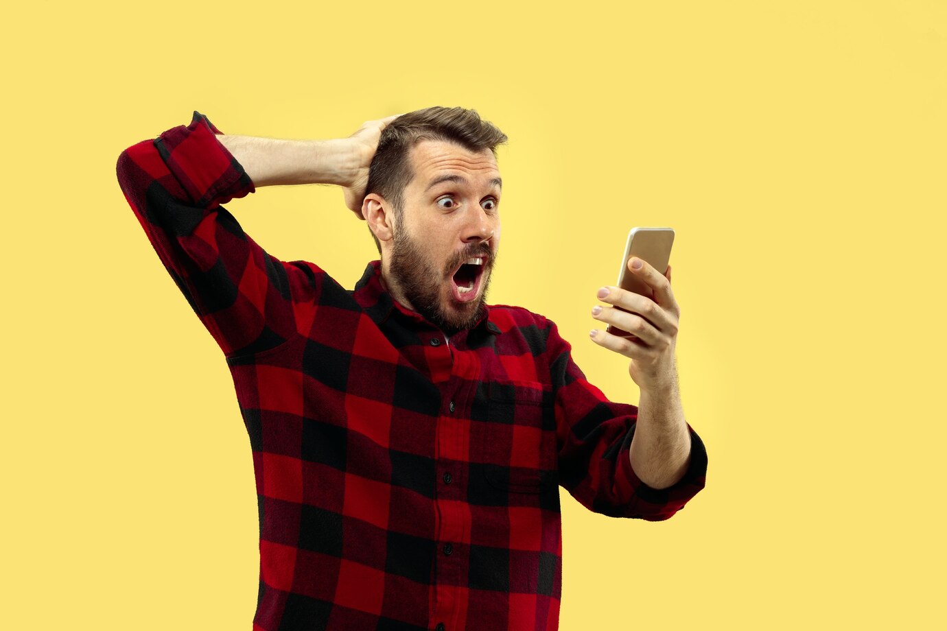 Un hombre emocionado mirando su teléfono | Fuente: Freepik