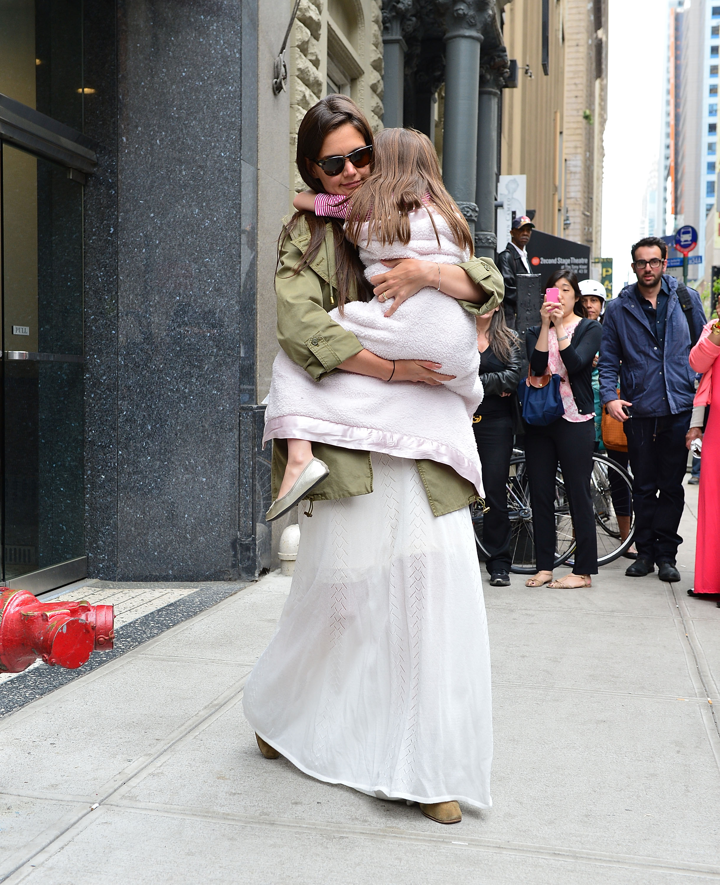 Katie Holmes abraza a su hija Suri Cruise mientras pasean por Manhattan el 18 de abril de 2012 | Fuente: Getty Images