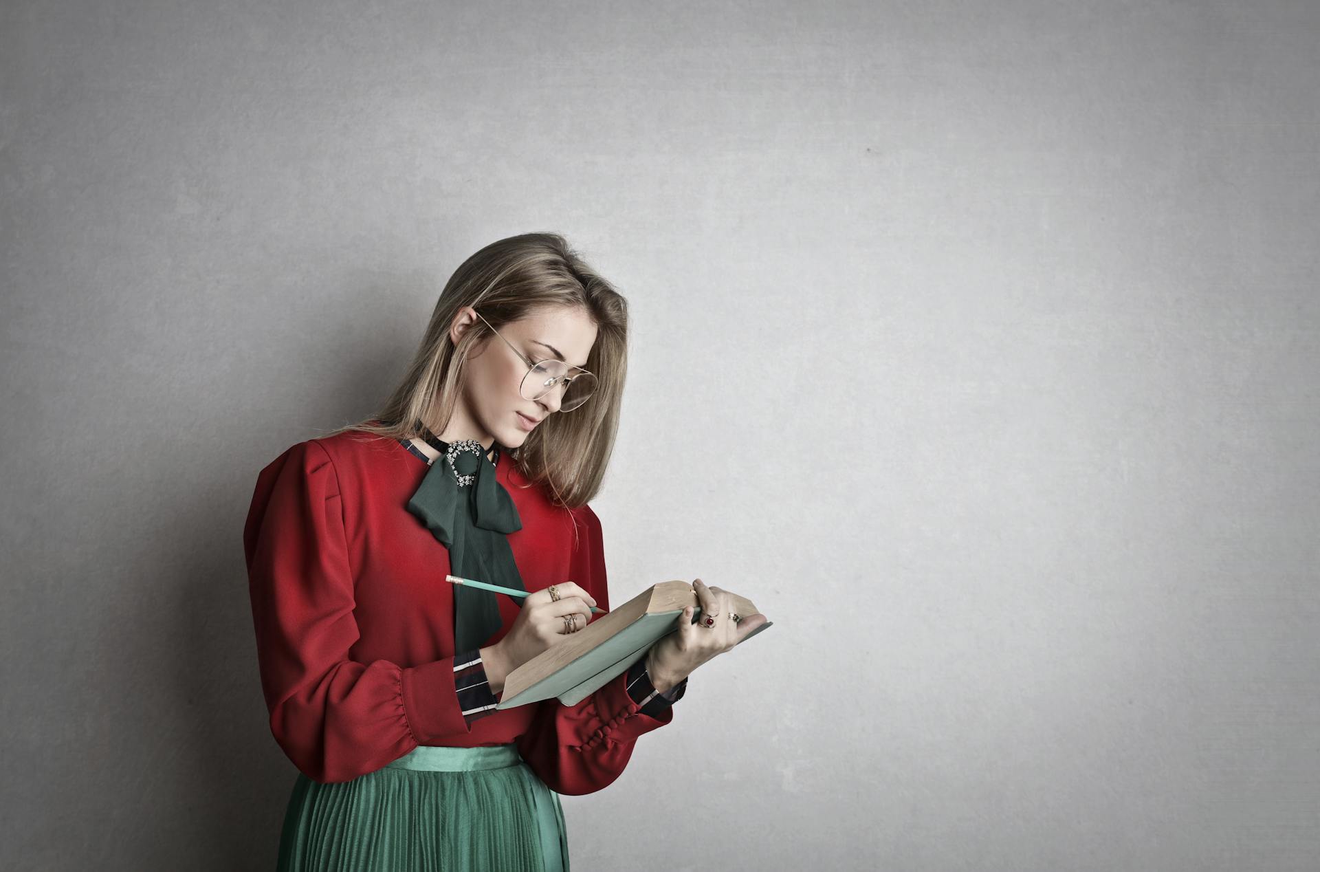 Una donna che prende appunti su un quaderno | Fonte: Pexels