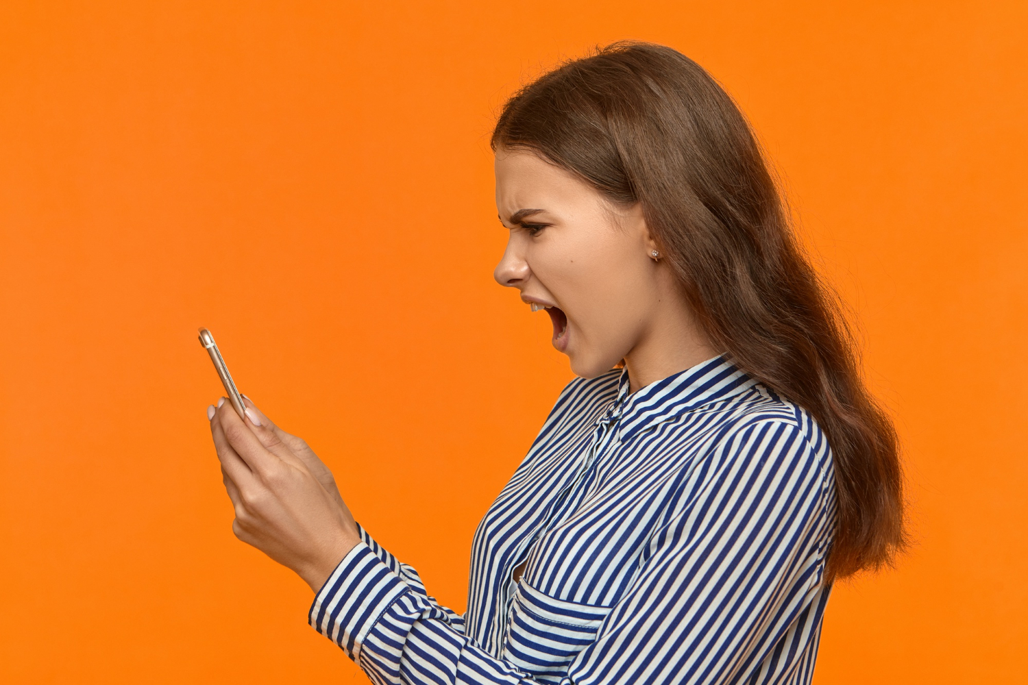 Una mujer furiosa mirando su teléfono y gritando | Fuente: Freepik