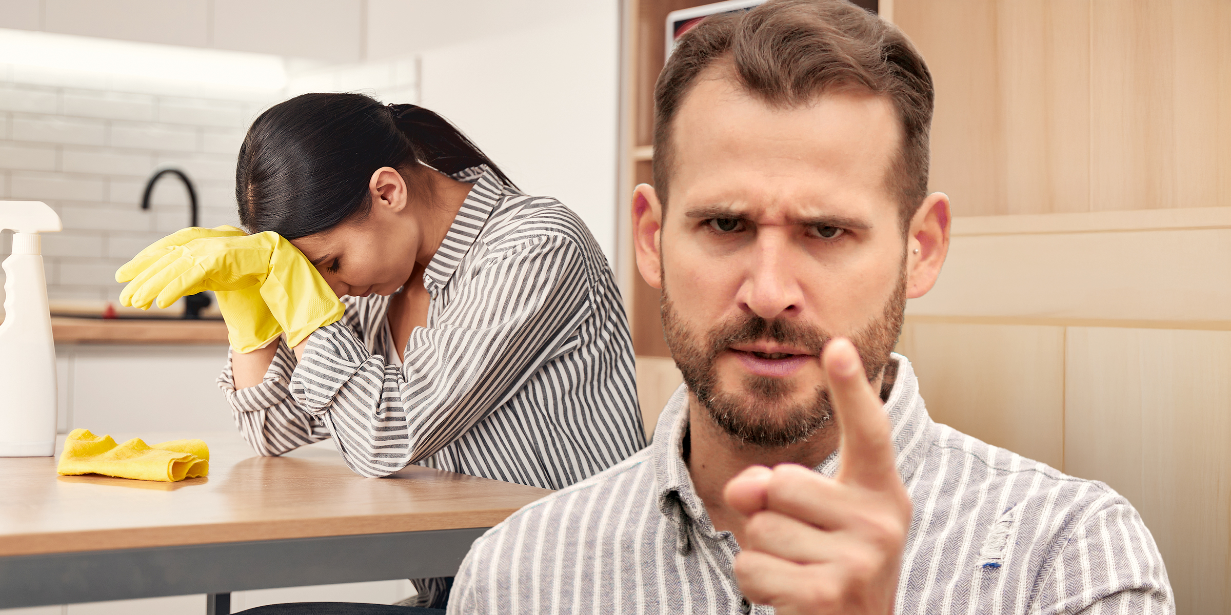 Una mujer frustrada intenta limpiar mientras su marido grita | Fuente: Shutterstock