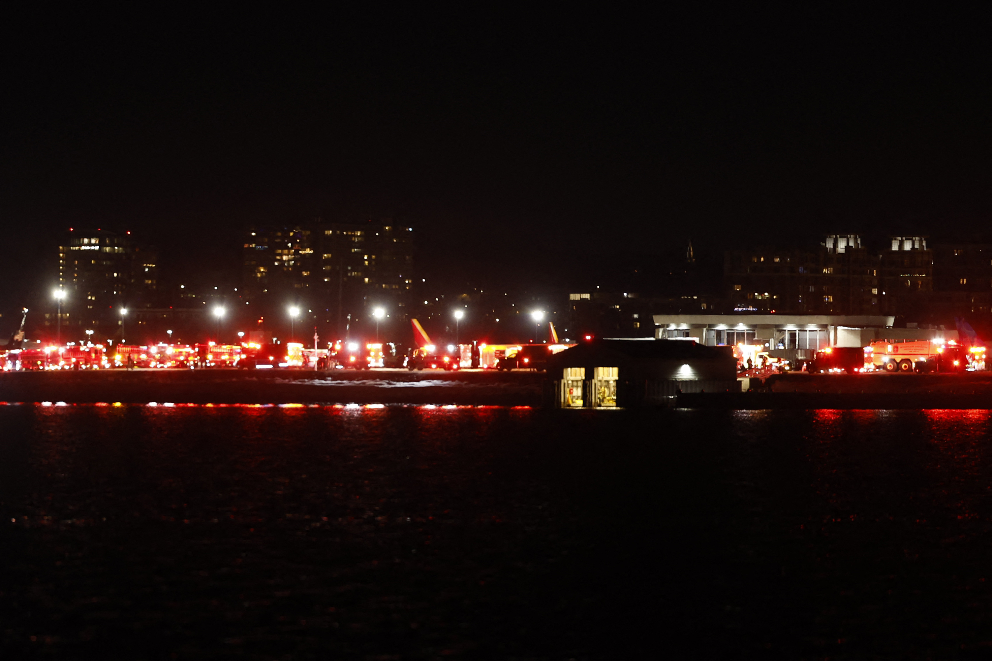 Se ven las luces de los vehículos de emergencia en el Aeropuerto Nacional Reagan de Washington, DC, tras un accidente aéreo cerca del río Potomac el 29 de enero de 2025. | Fuente: Getty Images