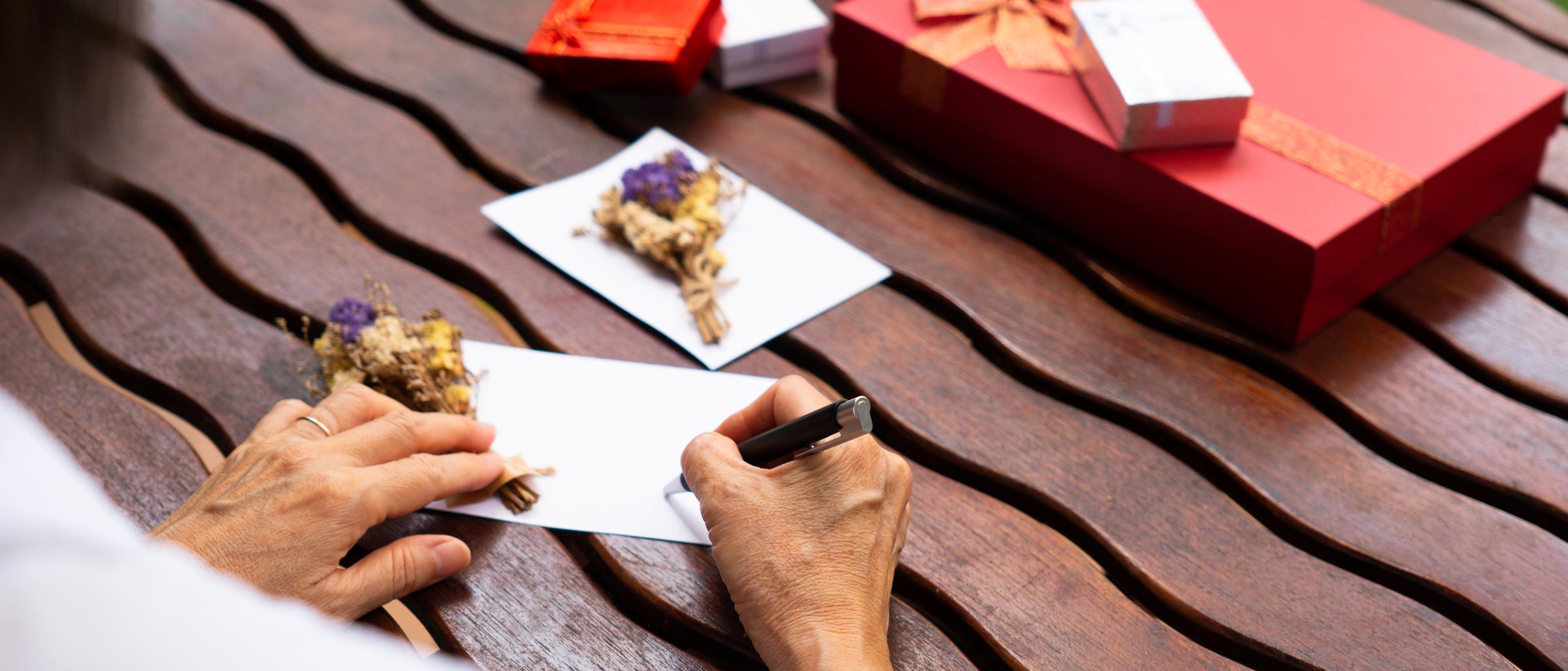 Una persona che scrive una cartolina | Fonte: Shutterstock