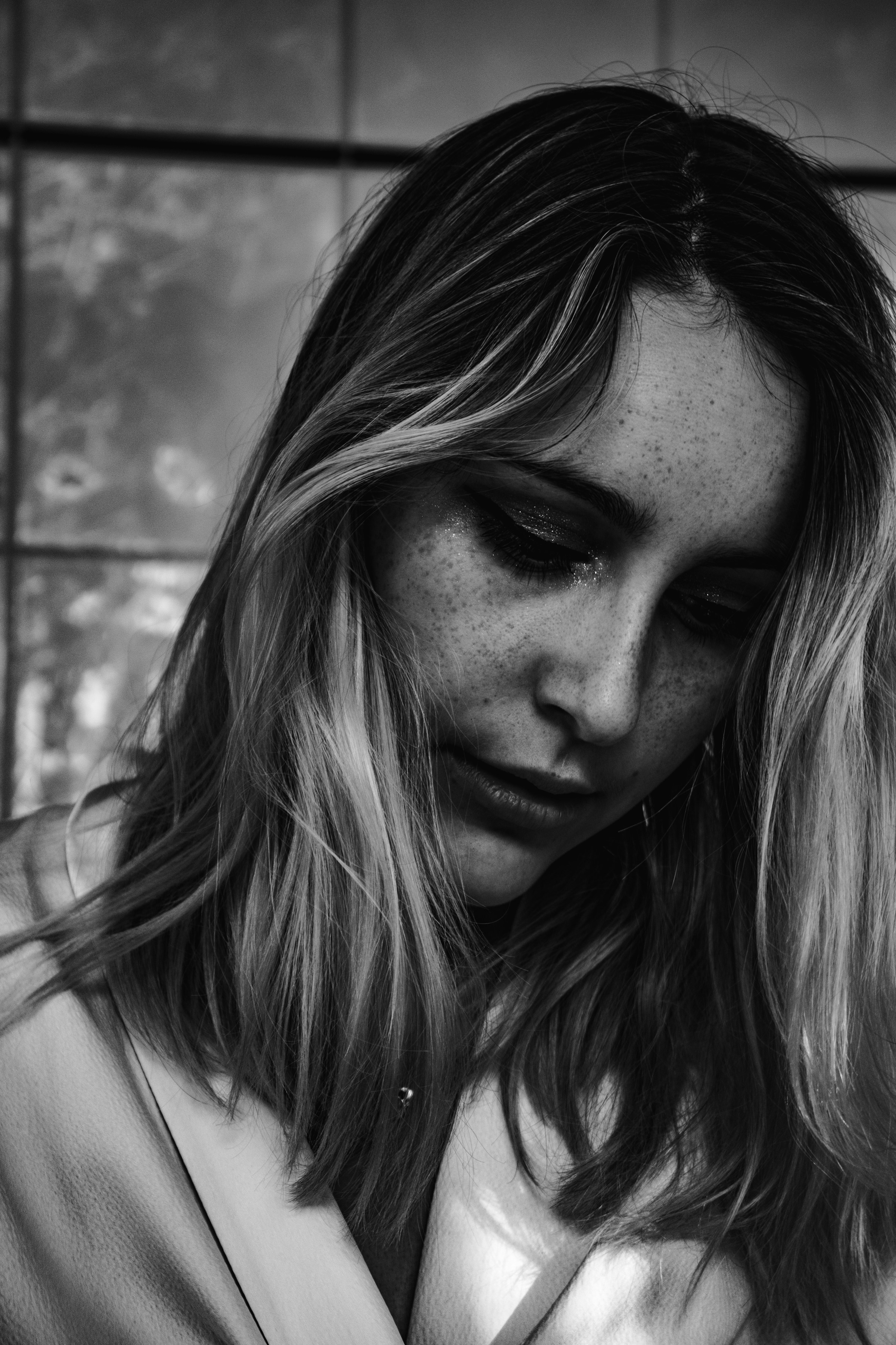 Foto in scala di grigi di una donna sconvolta | Fonte: Unsplash