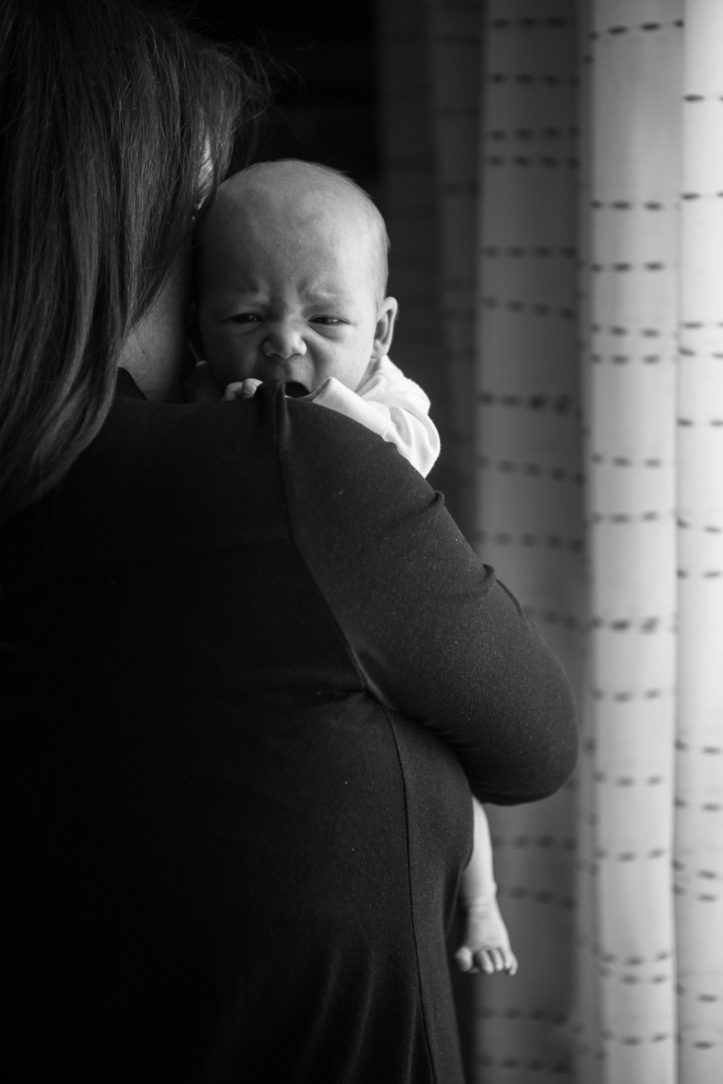 Primer plano de una mujer sujetando a un bebé que llora | Fuente: Unsplash