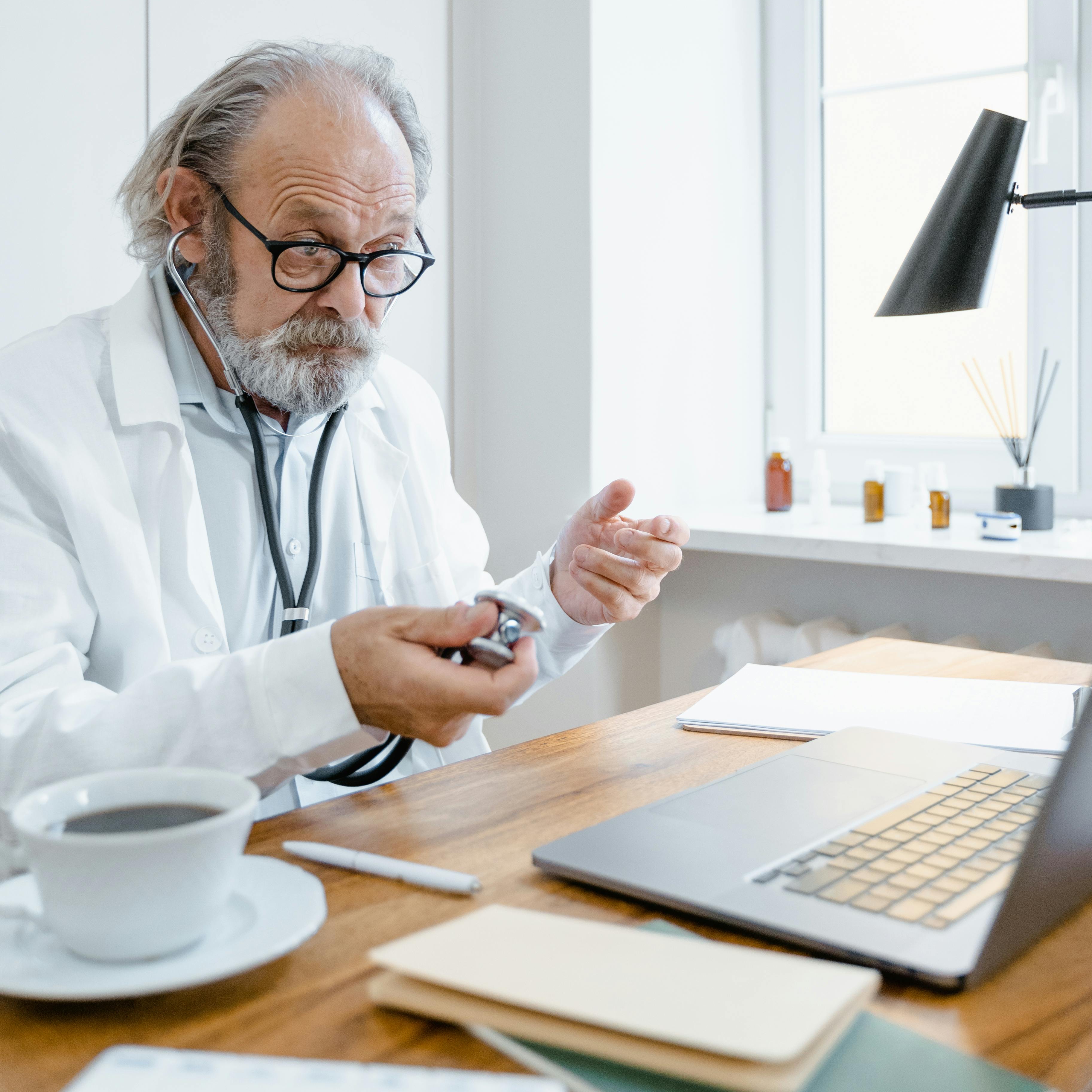 Un médico detrás de su mesa haciendo un gesto con la mano | Fuente: Pexels