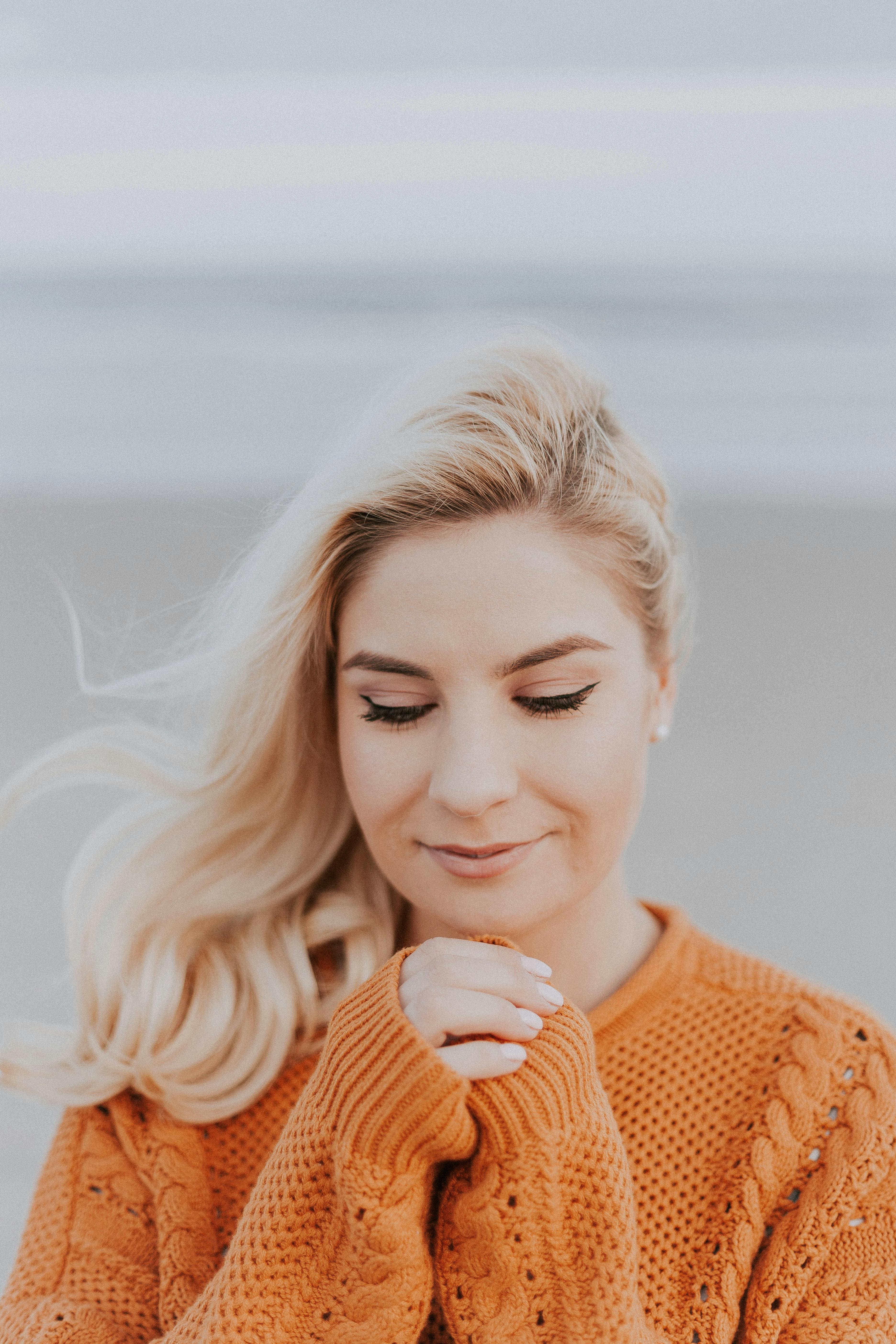 Mujer de pelo rubio con camiseta de punto naranja de manga larga | Foto: Pexels