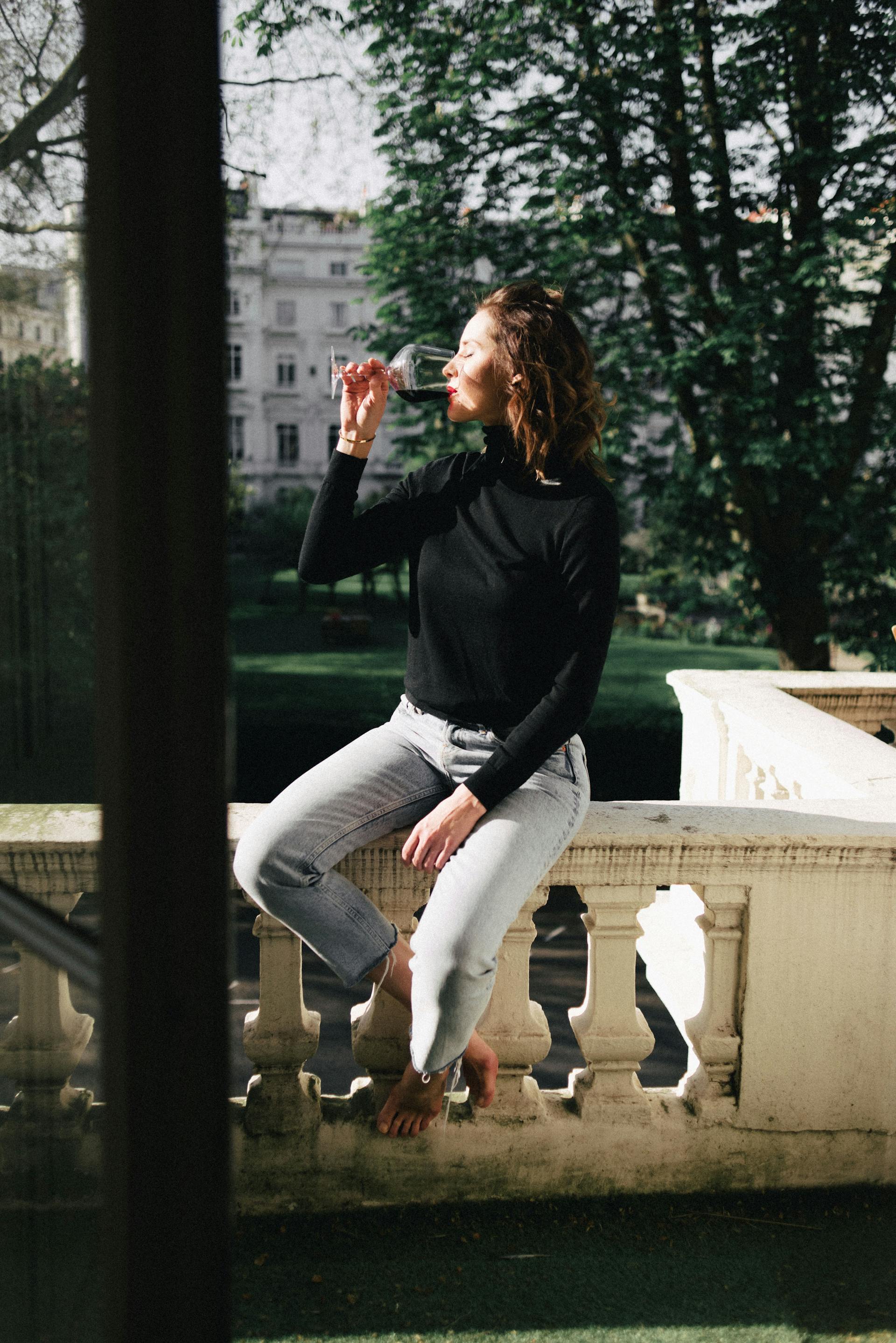 Una mujer feliz bebiendo vino | Fuente: Pexels