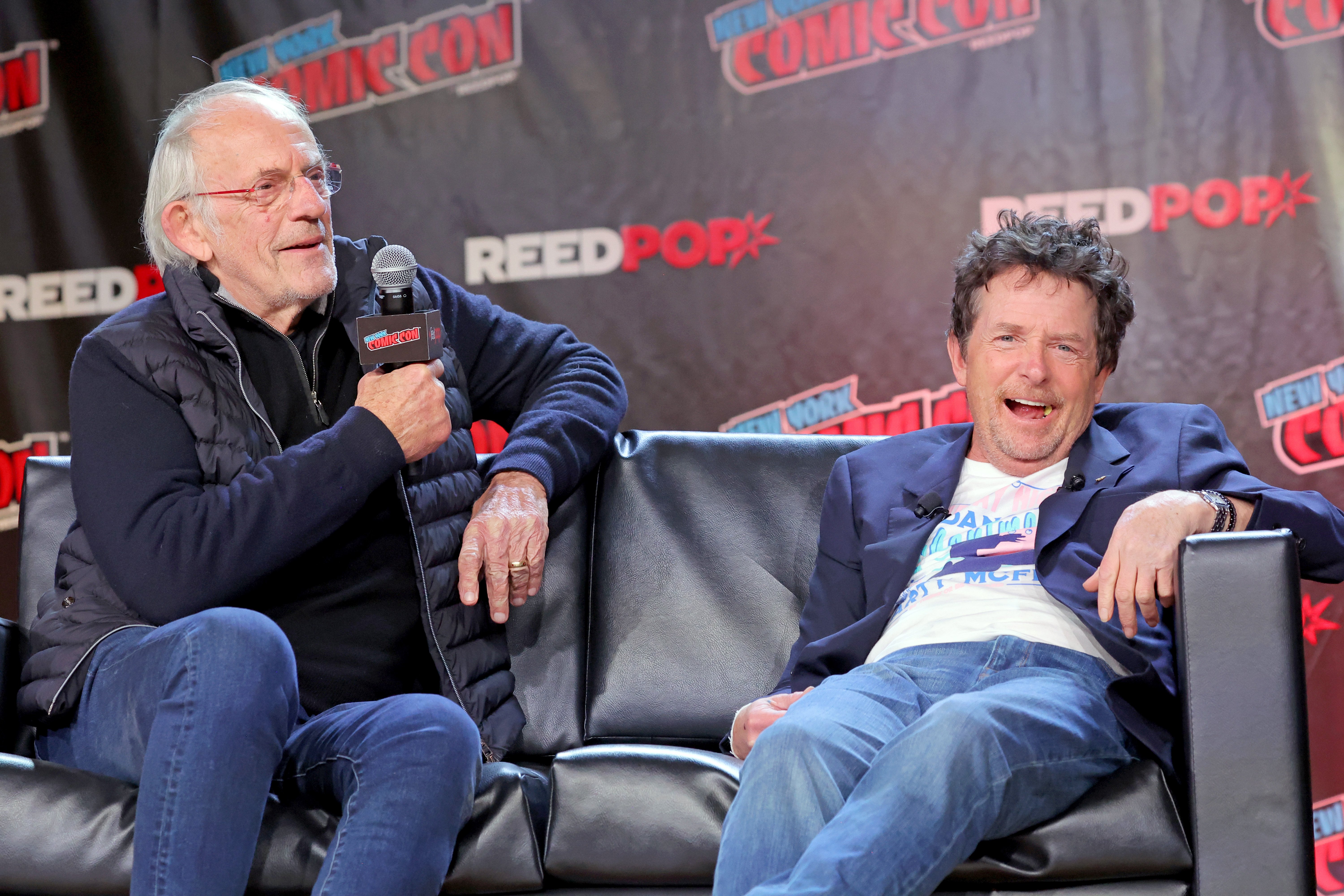 Christopher Lloyd (izq.) y Michael J. Fox asisten a un panel de "Back to the future" en la Comic Con de Nueva York el 8 de octubre de 2022 en la ciudad de Nueva York | Foto: Getty Images