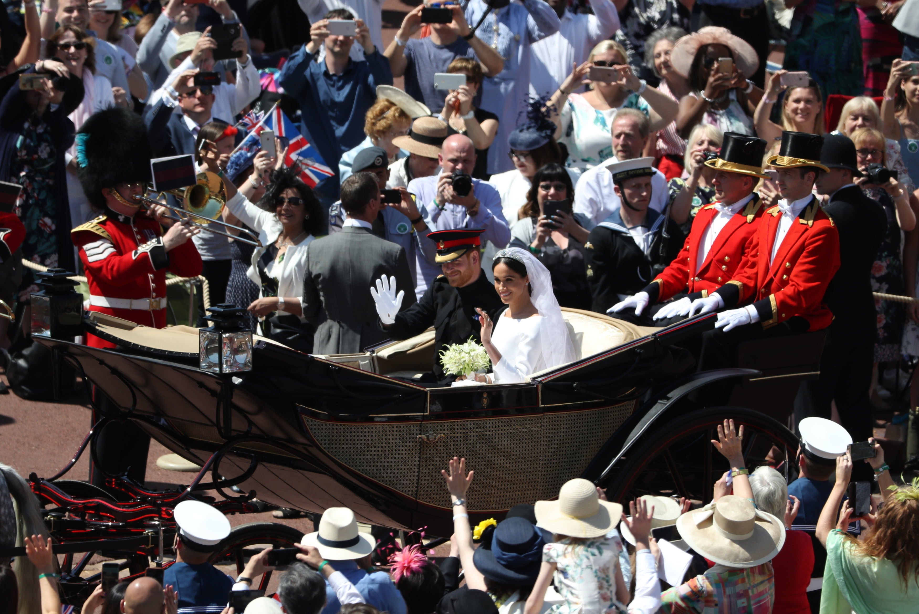 Las multitudes animan a los recién casados, el príncipe Harry y Meghan Markle en el carruaje de Ascot Landau el 19 de mayo de 2018 en Windsor, Inglaterra. | Foto: Getty Images