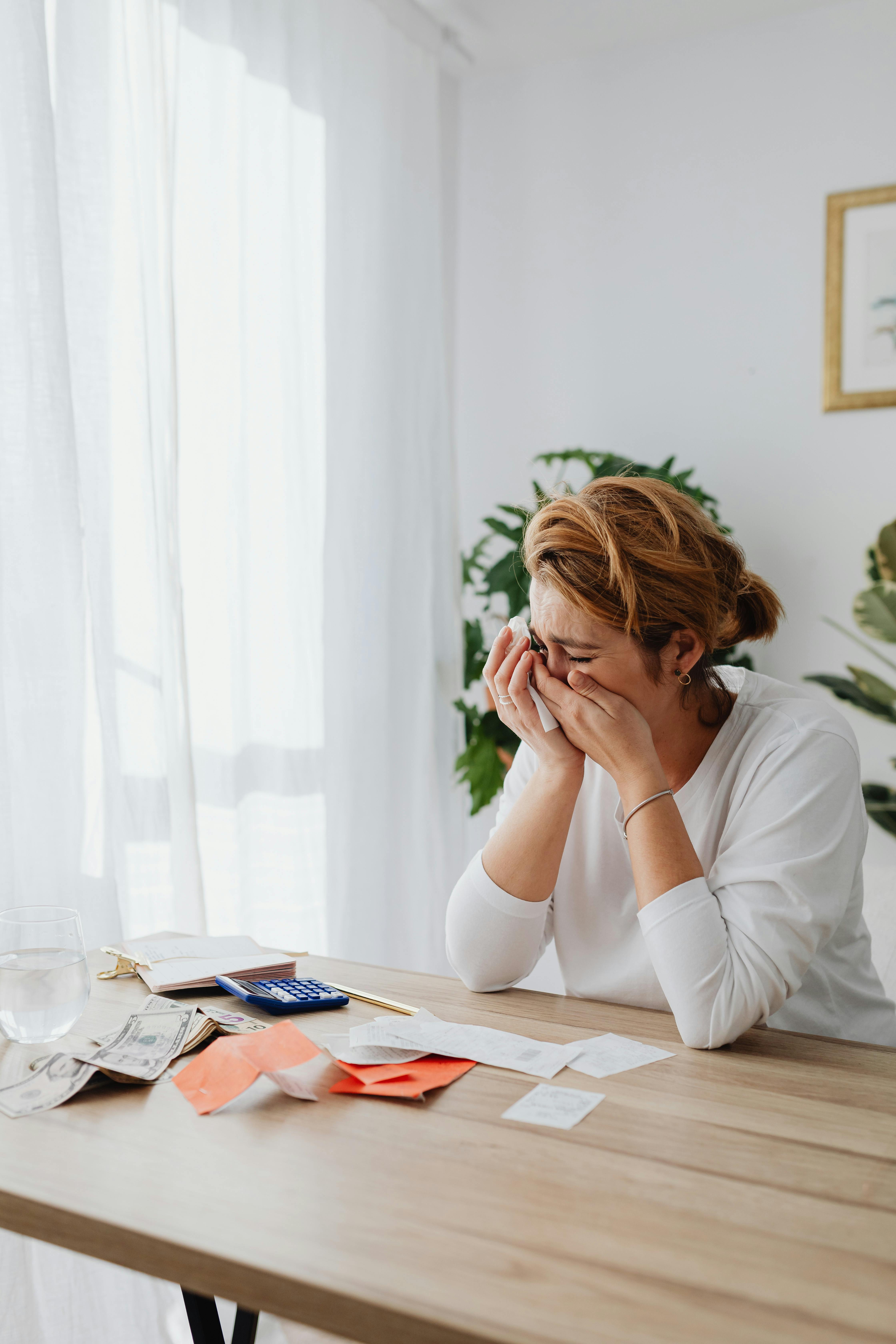 Una mujer llora mientras hace papeleo | Fuente: Pexels