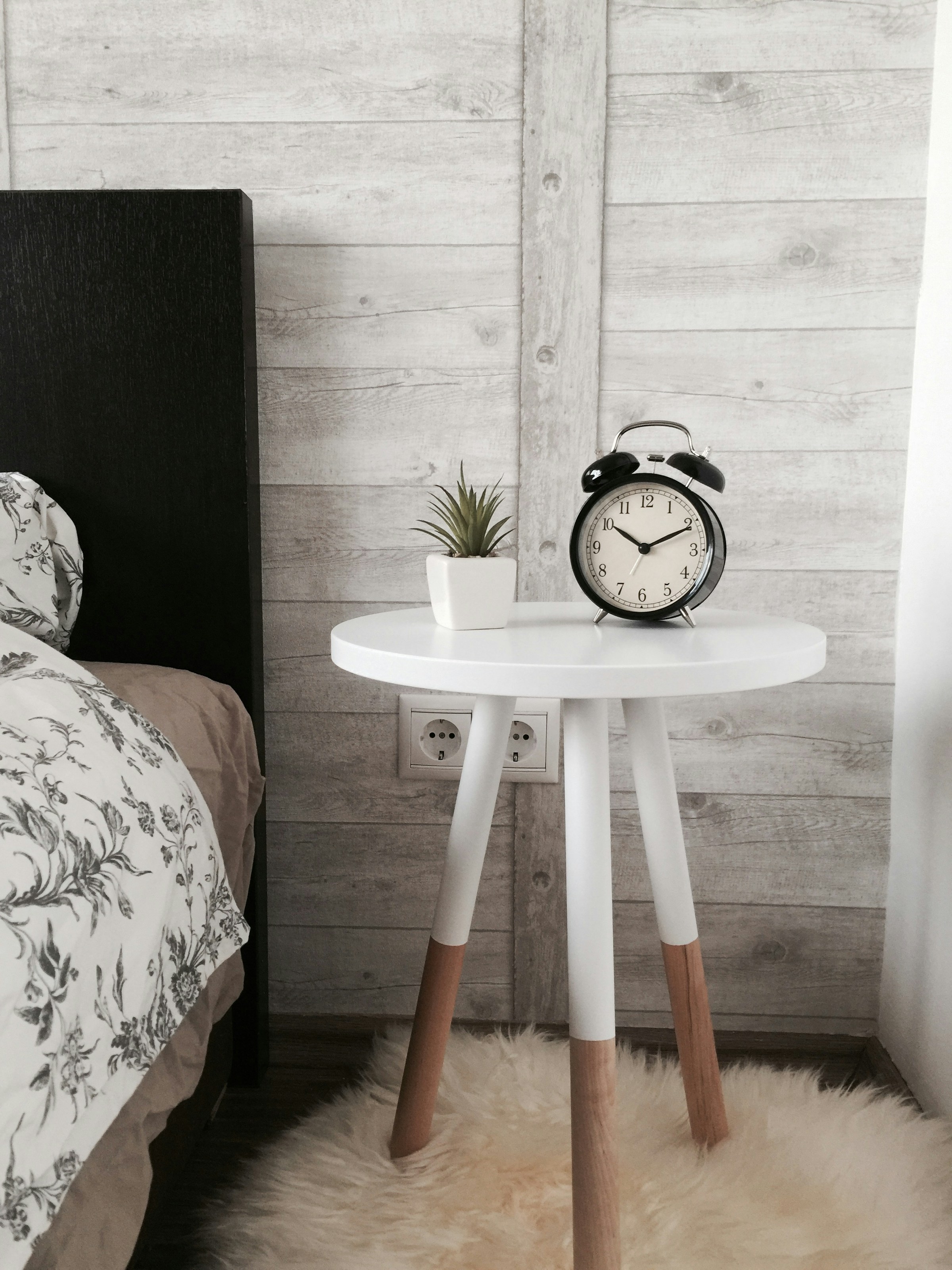 Un reloj despertador sobre una mesa de madera en una habitación | Fuente: Unsplash