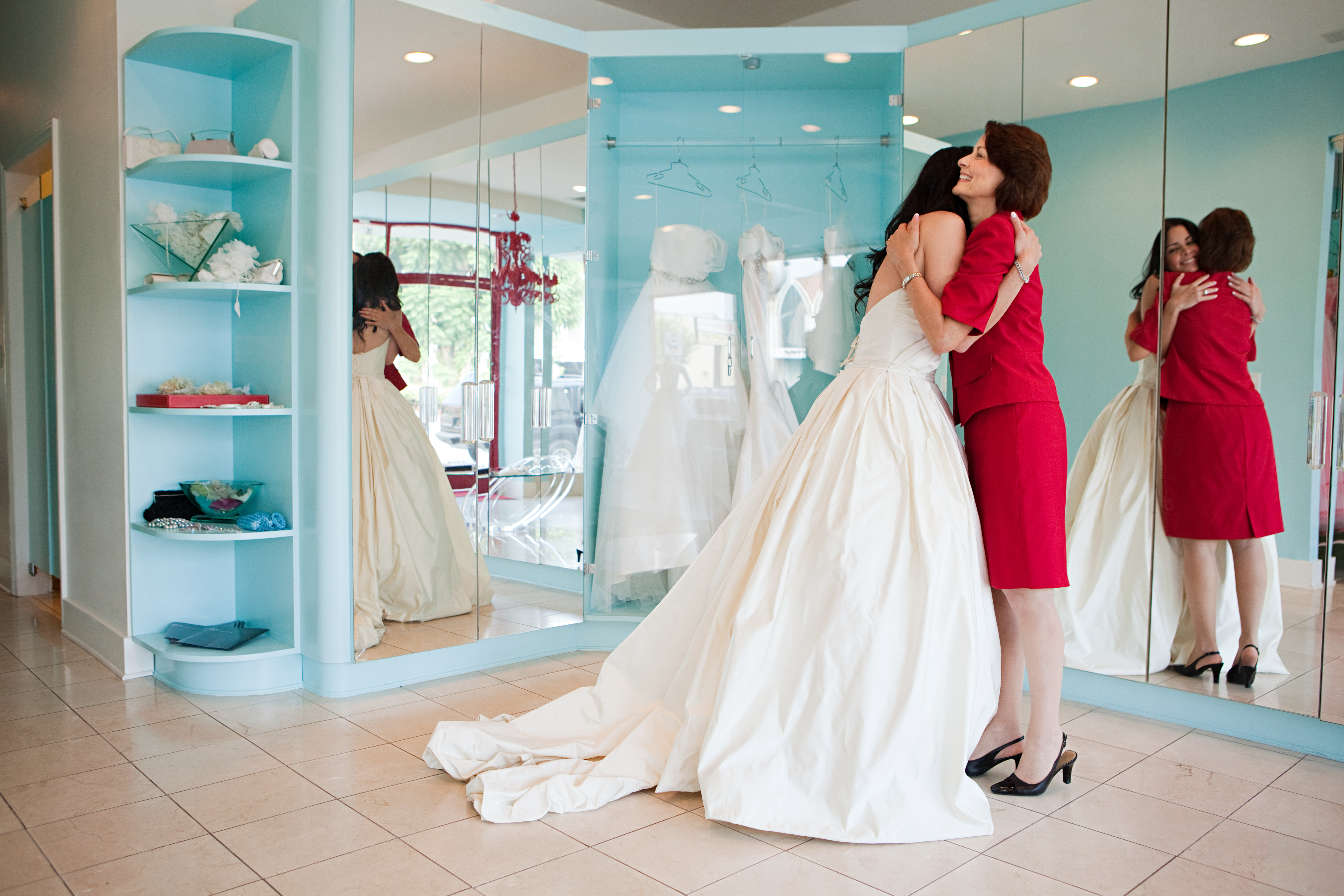 Hija probándose vestido de novia, abrazando a su madre | Fuente: Getty Images