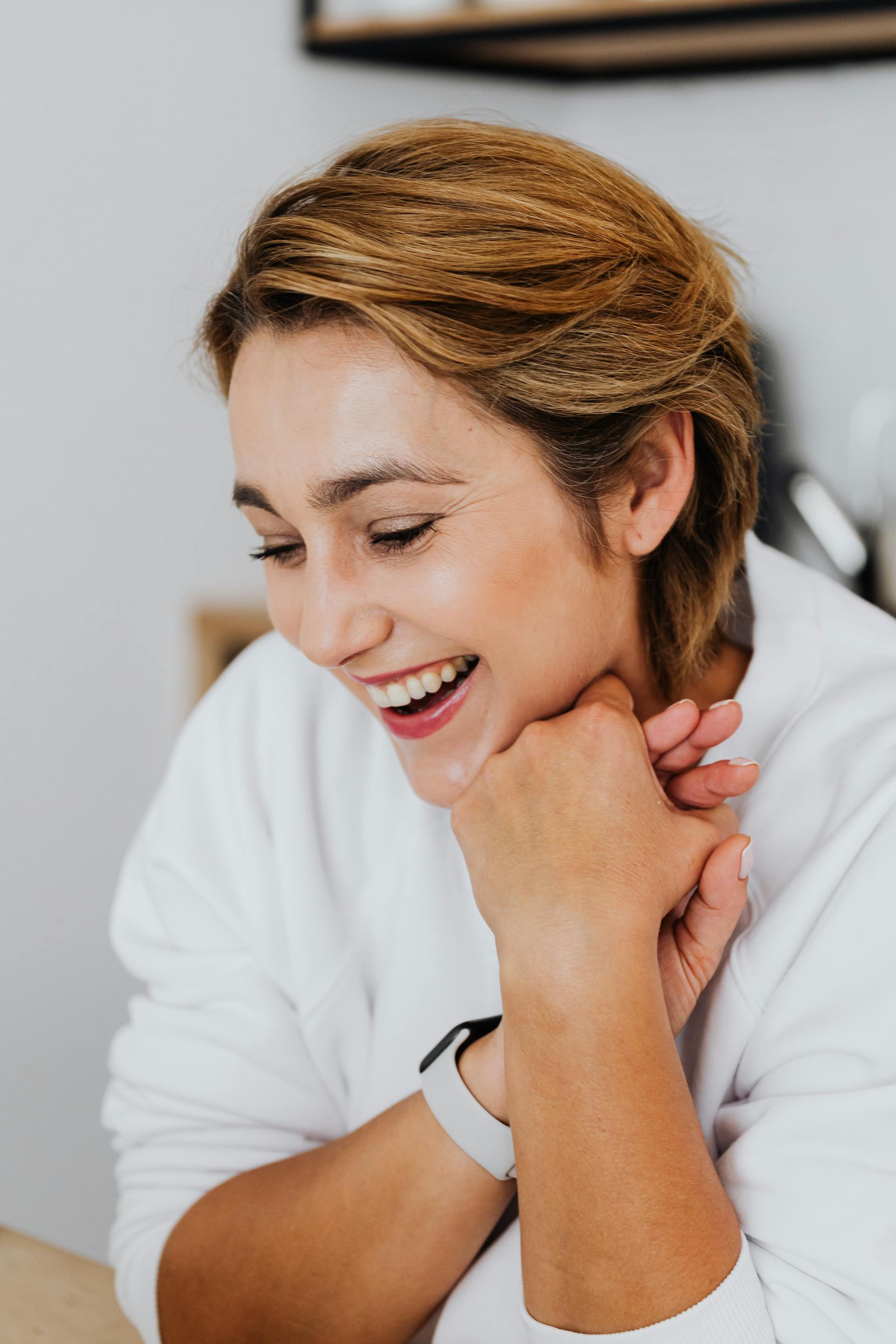 Una mujer sonriendo en una habitación | Fuente: Pexels