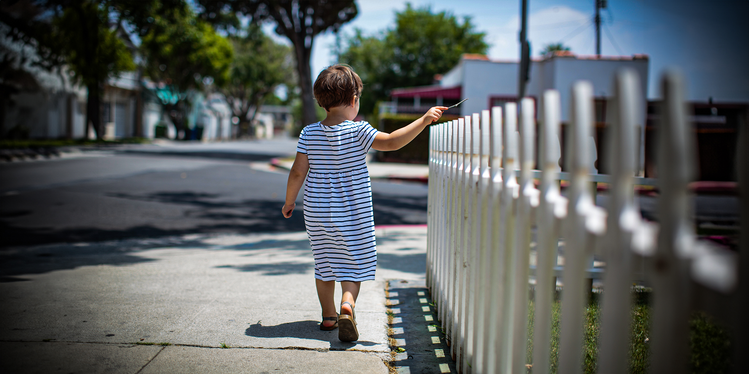 Una niña caminando cerca de una valla | Fuente: Shutterstock