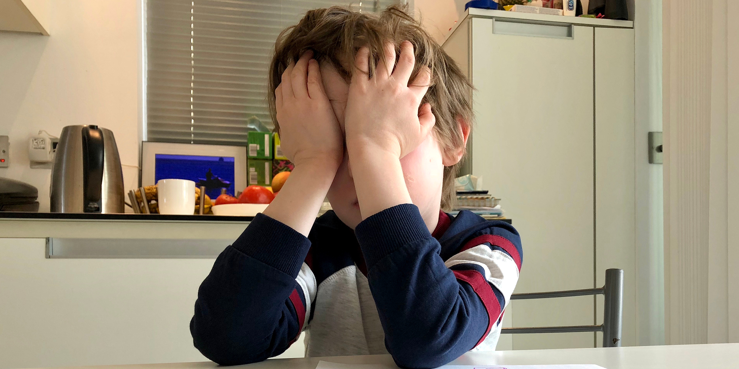 Un niño cubriéndose la cara con las manos | Fuente: Shutterstock