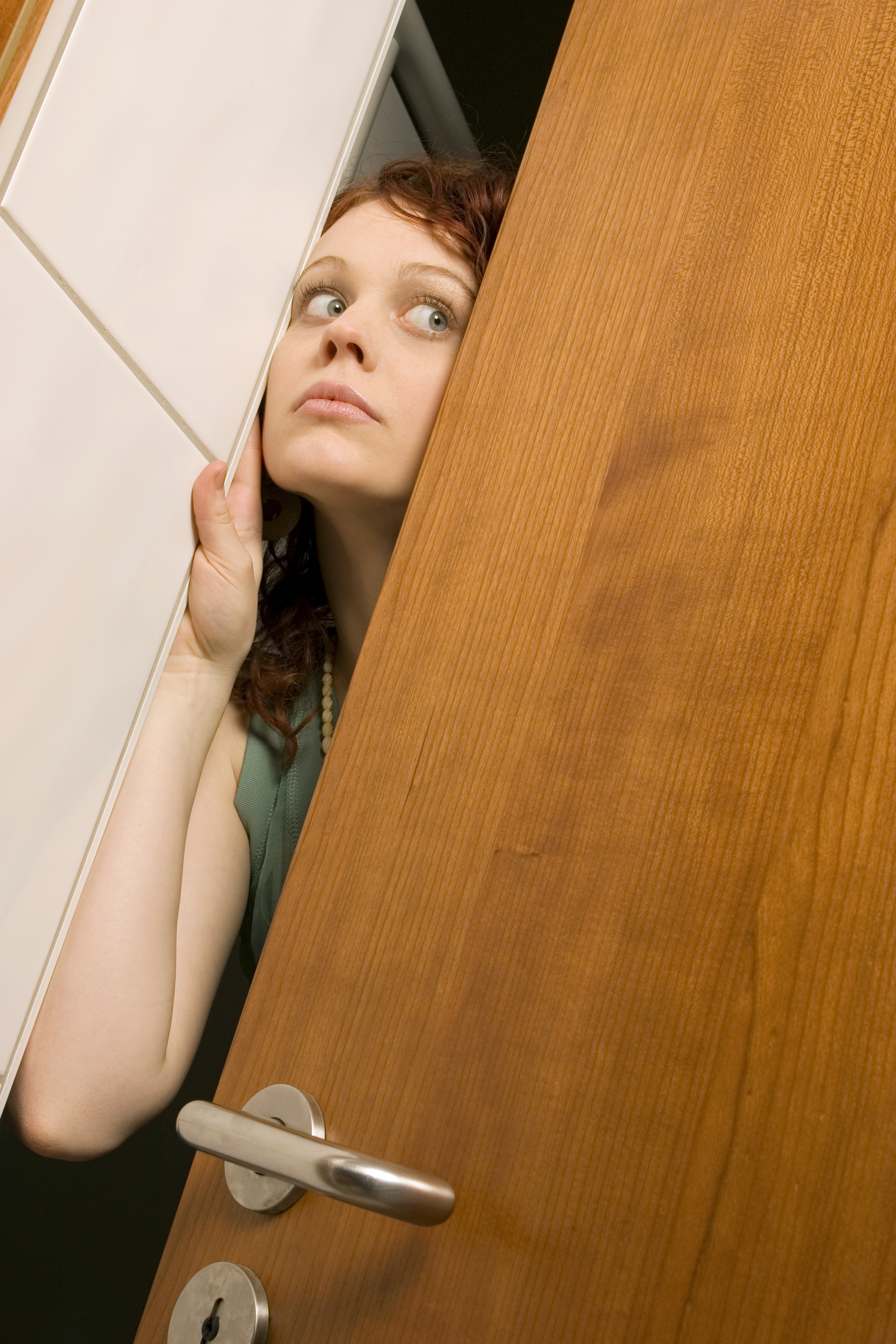 Mujer asomando la cabeza por una puerta | Foto: Getty Images