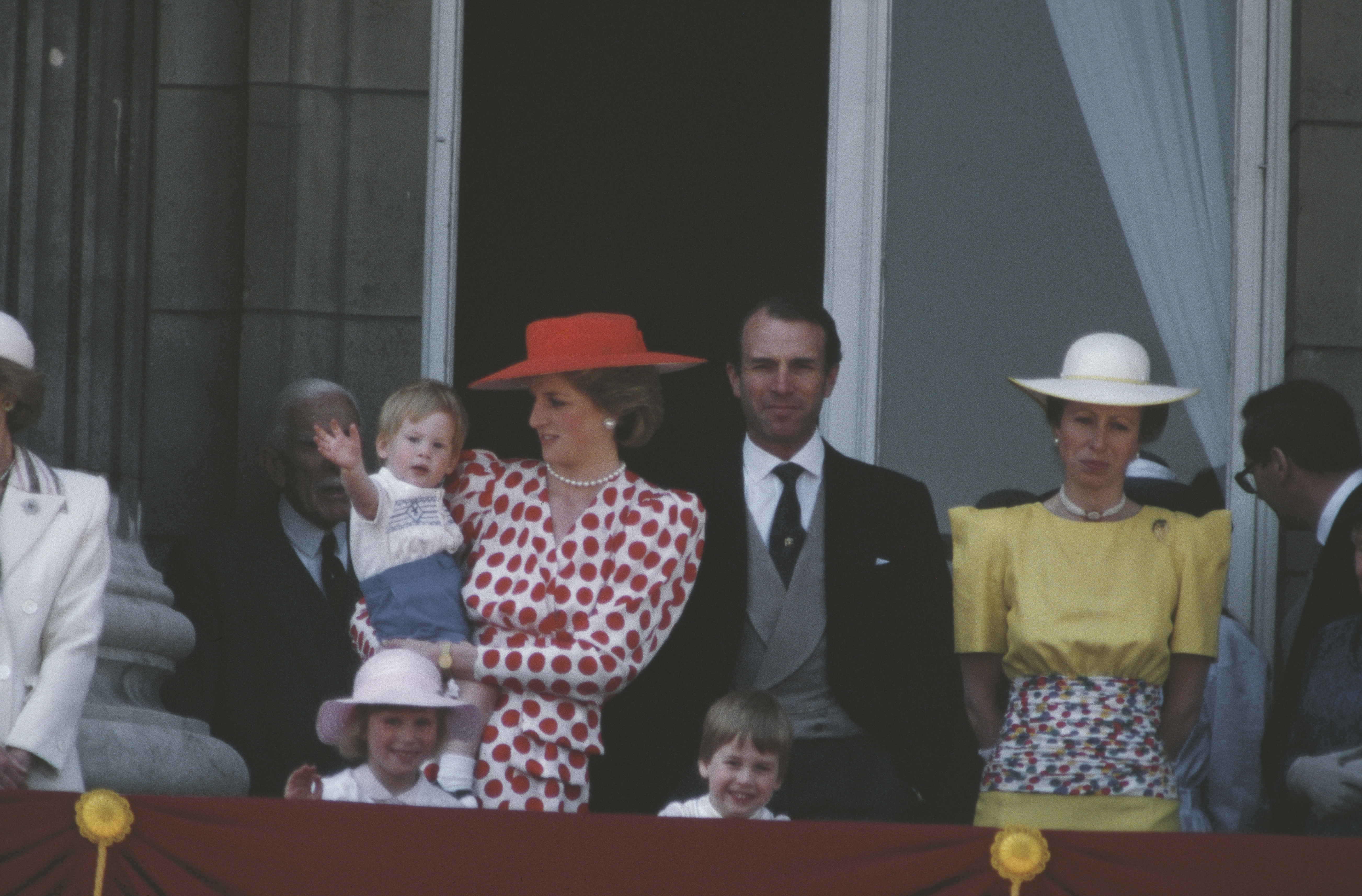 La princesa Diana sostiene al príncipe Harry, con el príncipe William, la princesa Anne y Mark Phillips en el balcón para la ceremonia Trooping the Colour en junio de 1986. | Foto: Getty Images