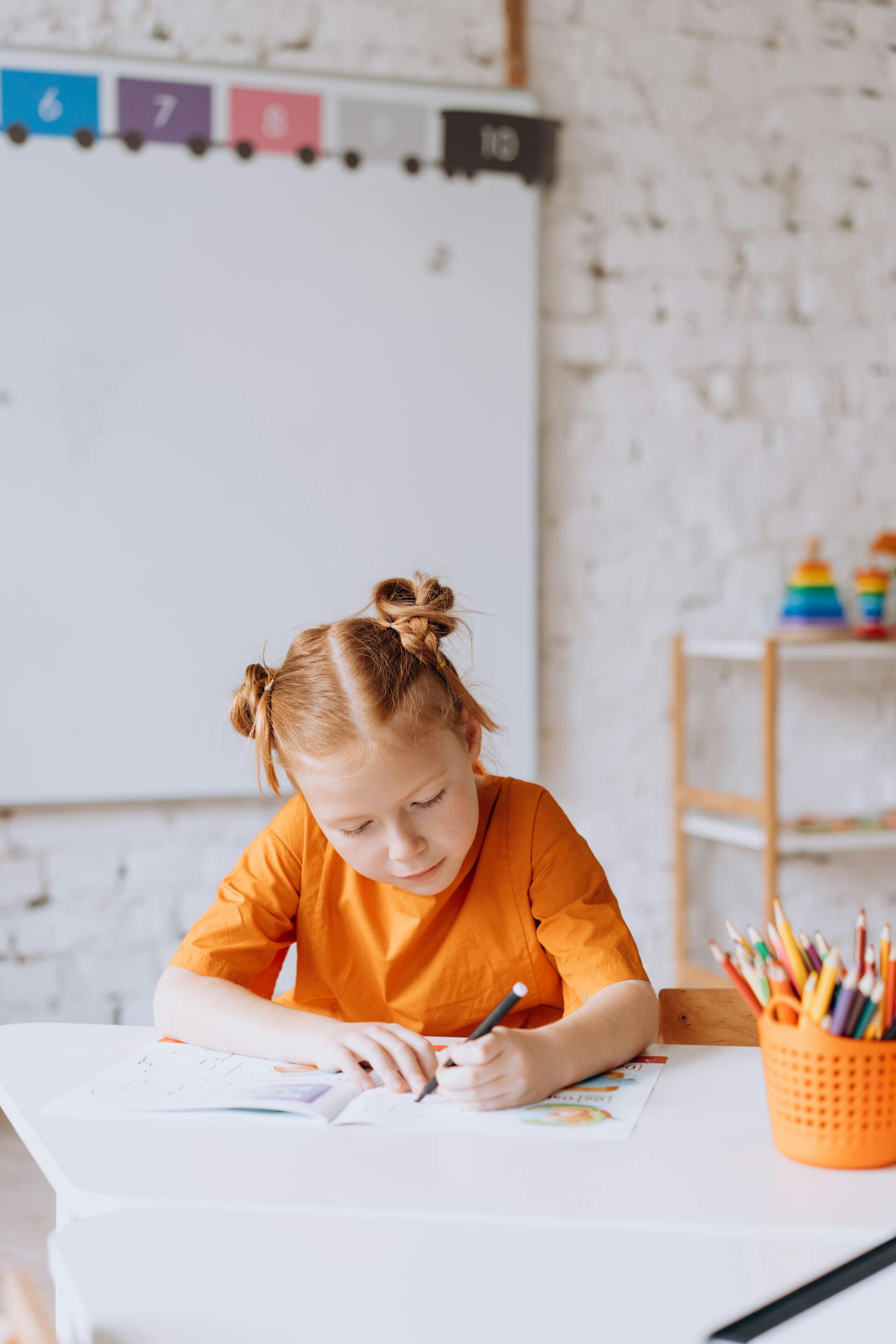 Una niña coloreando en un libro | Fuente: Pexels