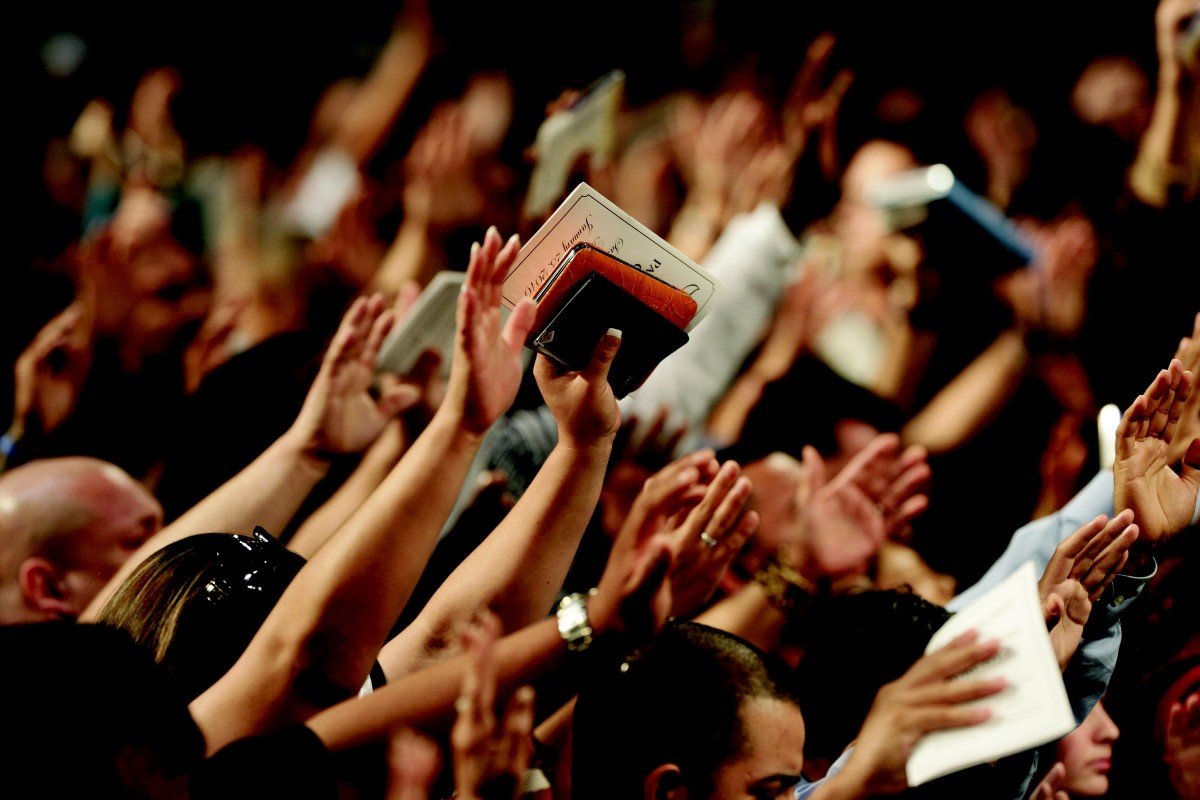 Fieles de la iglesia orando con sus manos elevadas. | Imagen: PxHere