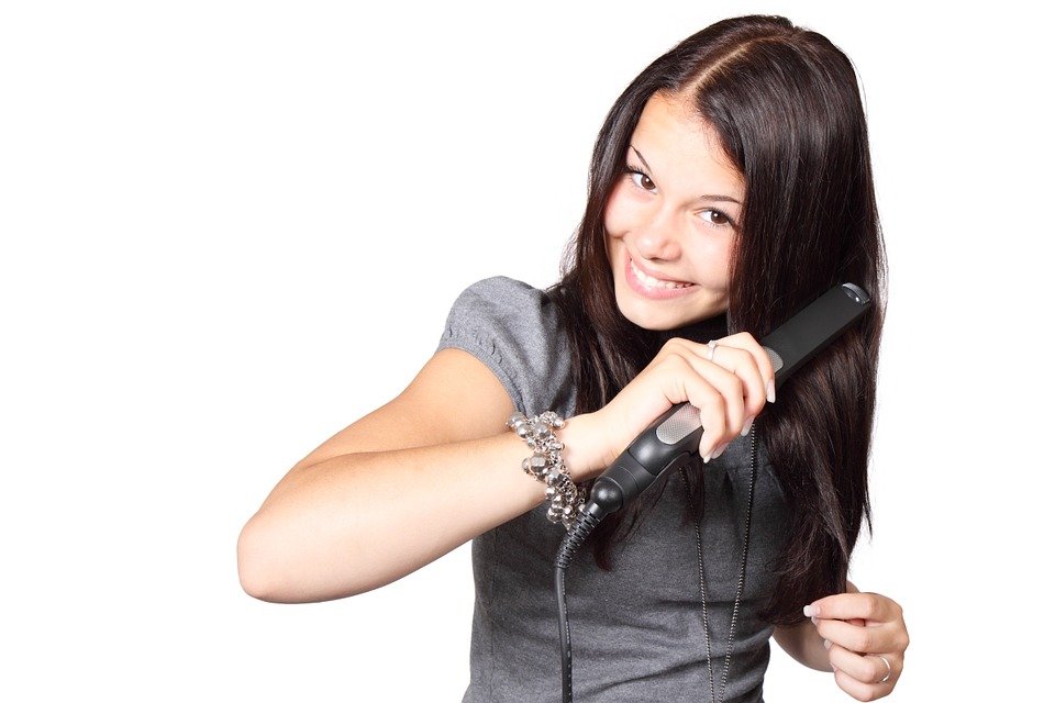 Mujer planchando su cabello. | Foto: Pixabay.