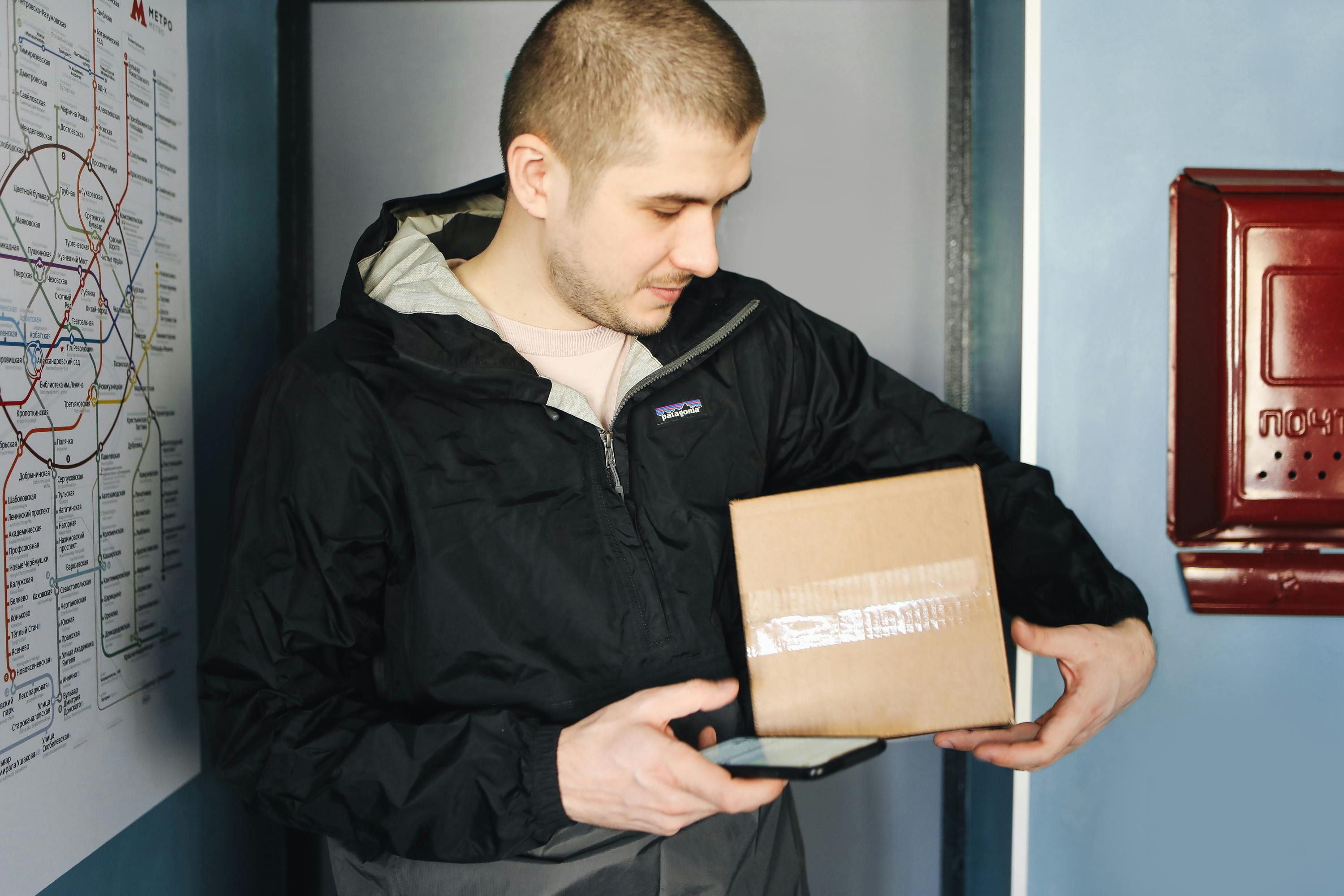 Repartidor sujetando una caja de cartón | Fuente: Pexels