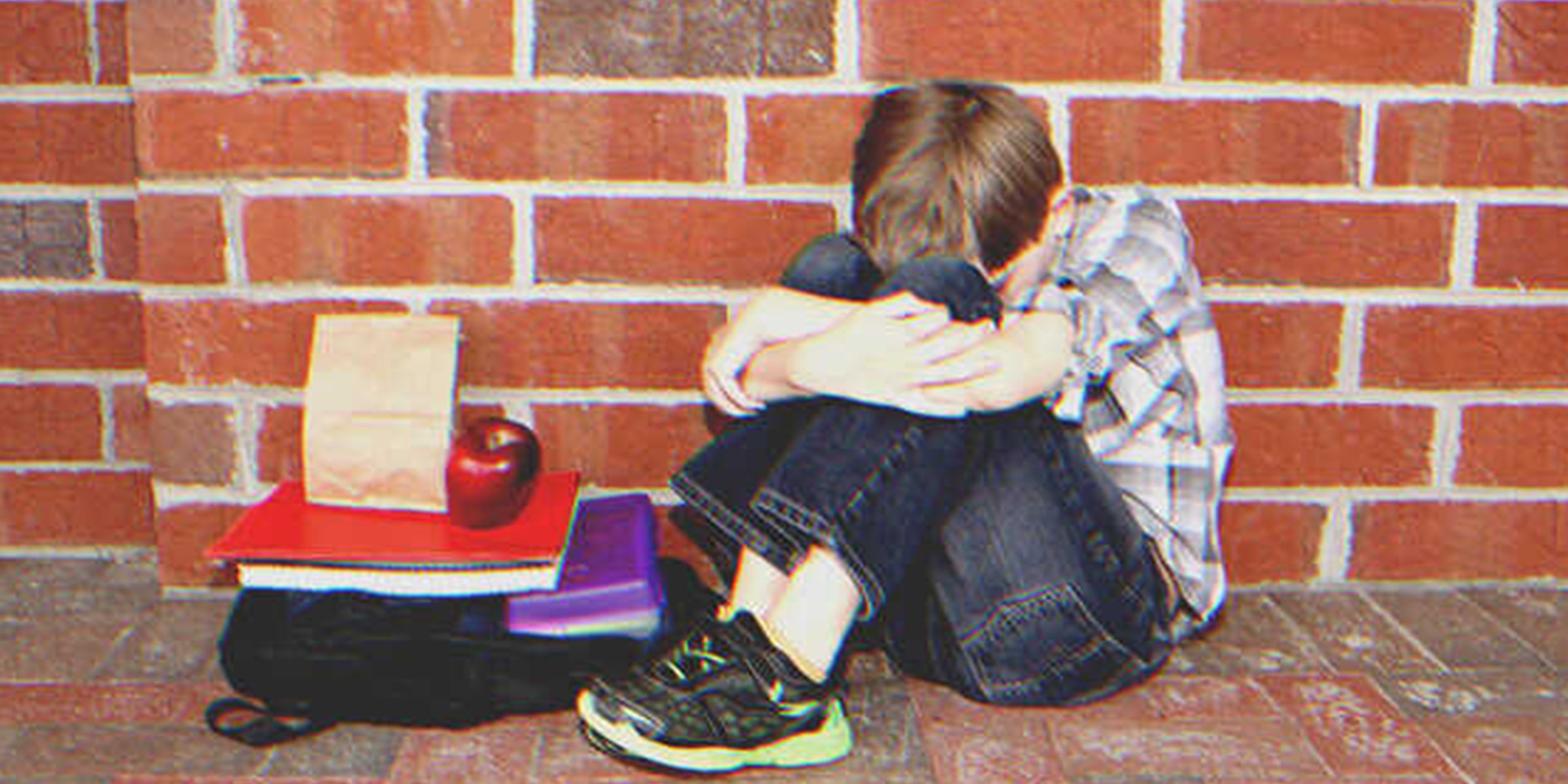 Un niño triste sentado en la calle | Foto: Shutterstock