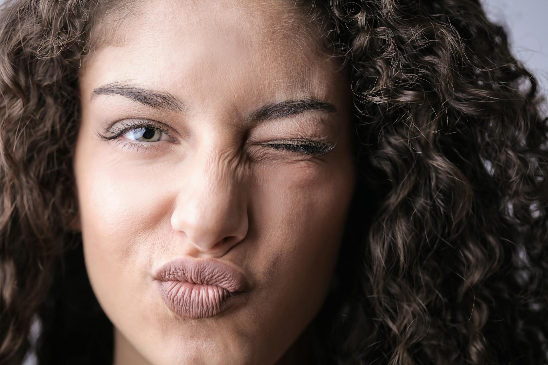 Una mujer guiñando el ojo | Fuente: Pexels