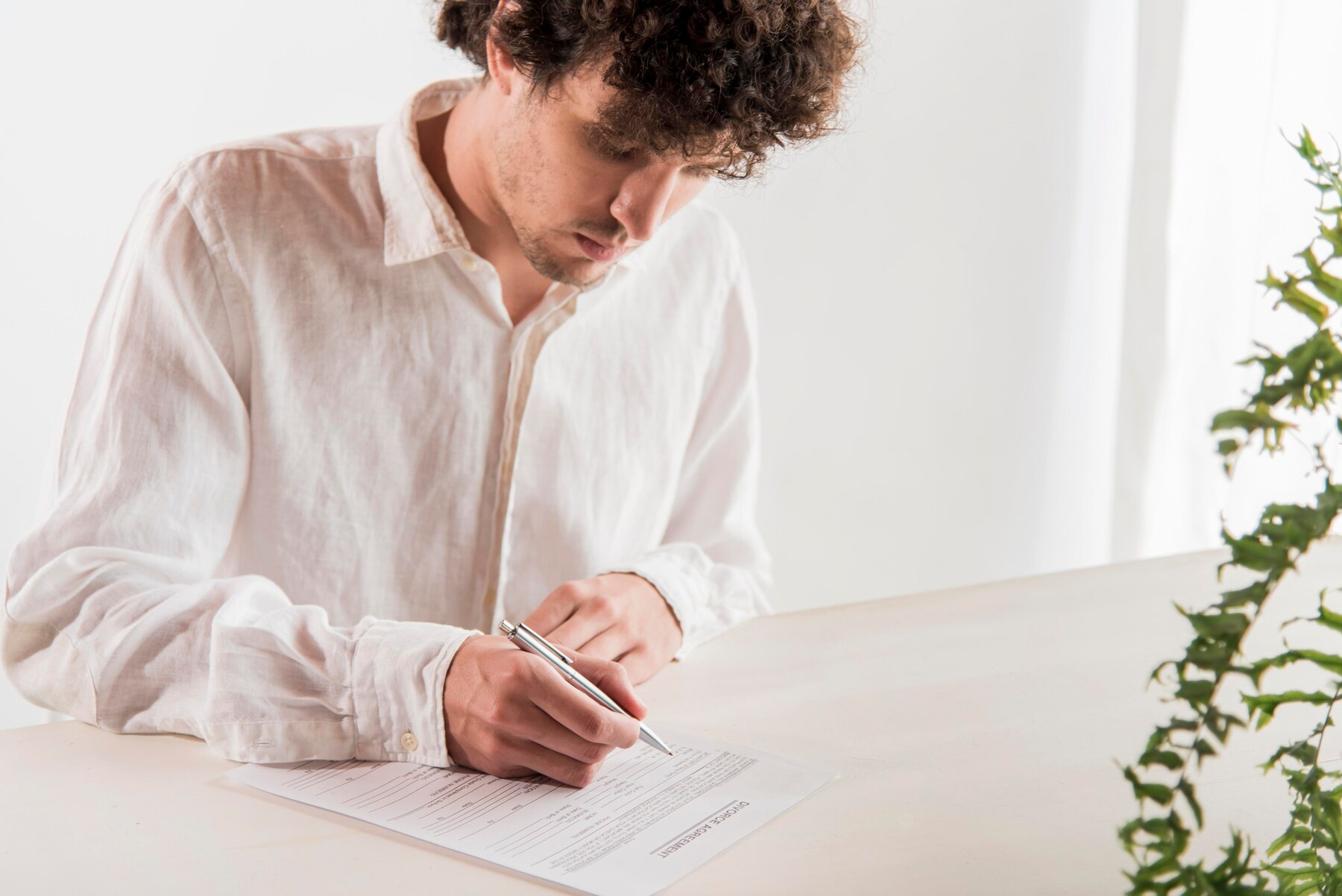 Un hombre firmando un documento | Fuente: Freepik