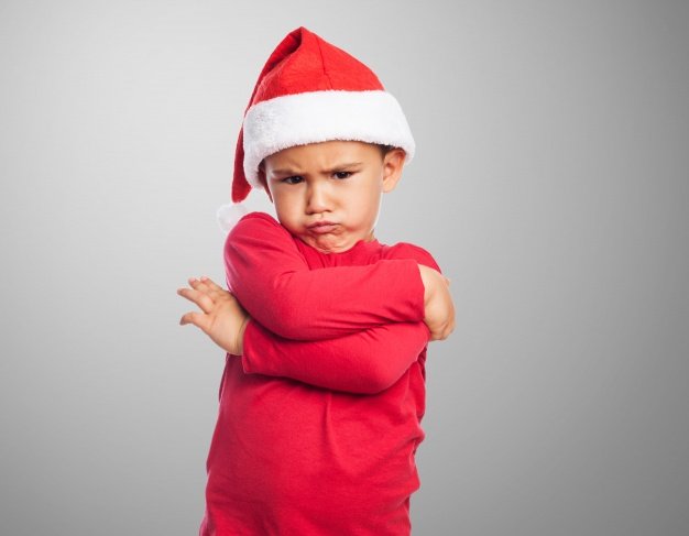 Niño molesto vestido con un atuendo navideño. │Foto: Freepik
