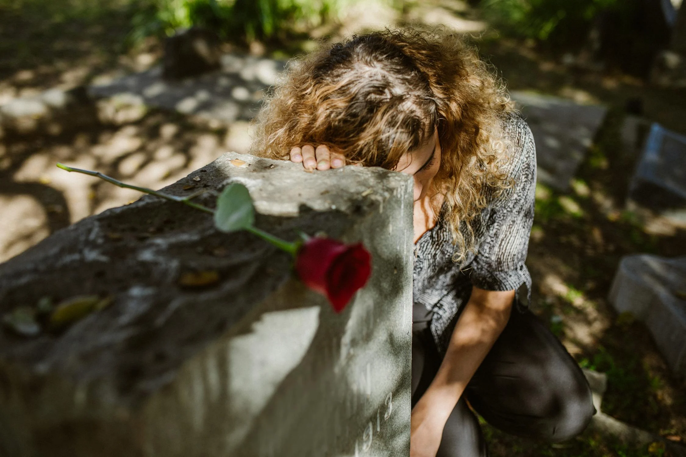 Una mujer afligida y una rosa | Fuente: Pexels