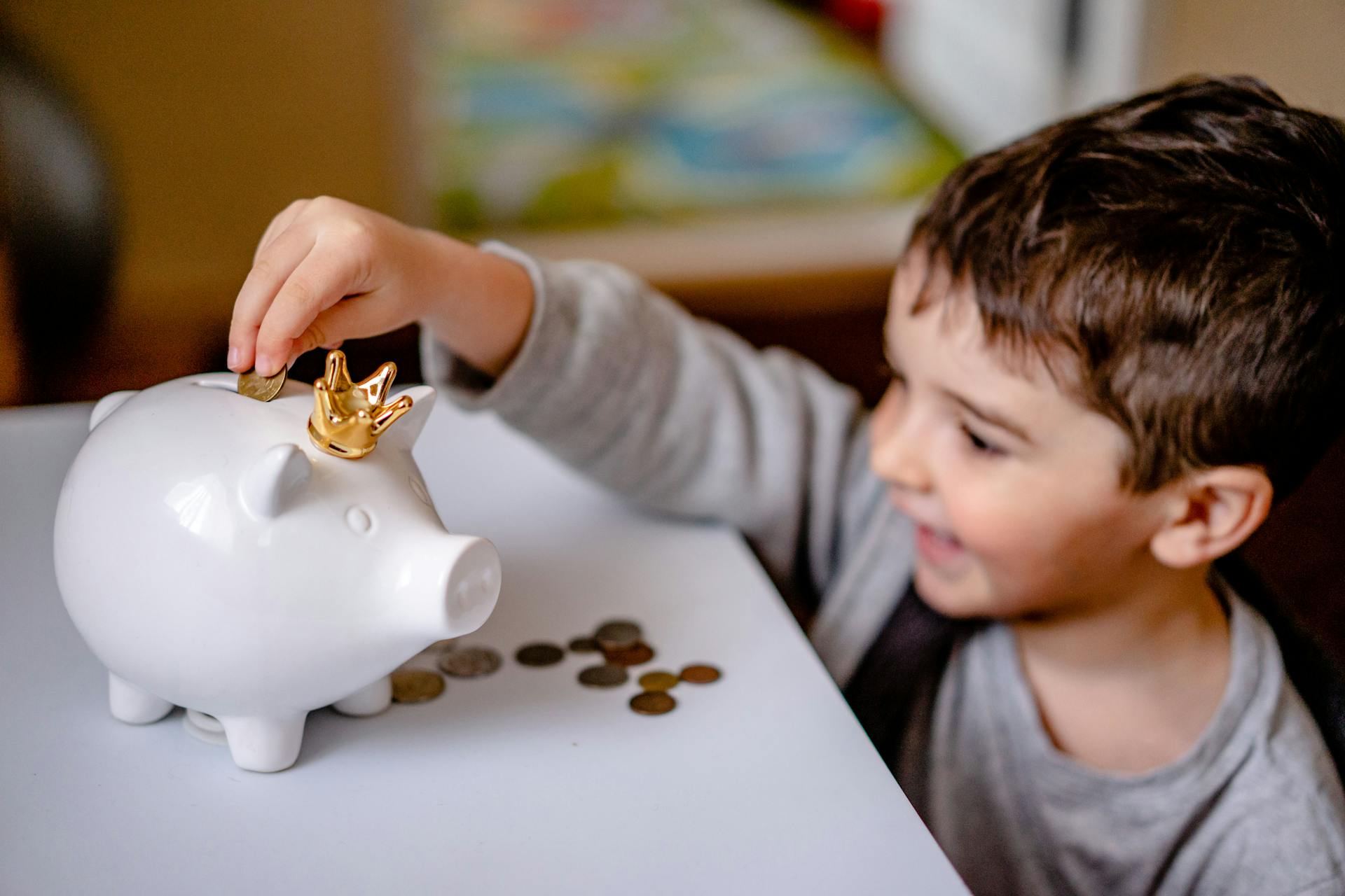 Un niño metiendo monedas en una hucha | Fuente: Pexels