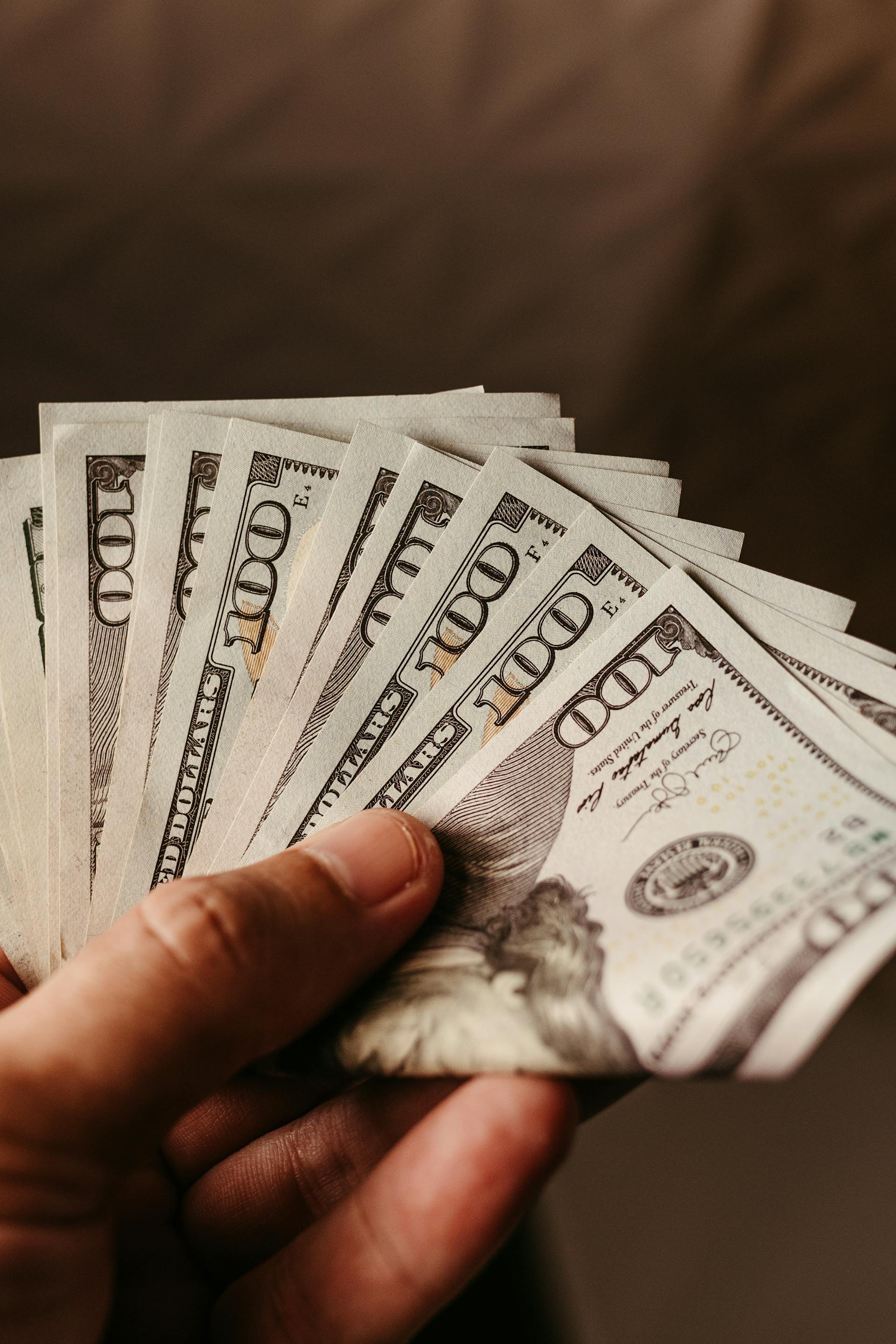 Un hombre con dinero en la mano | Fuente: Pexels