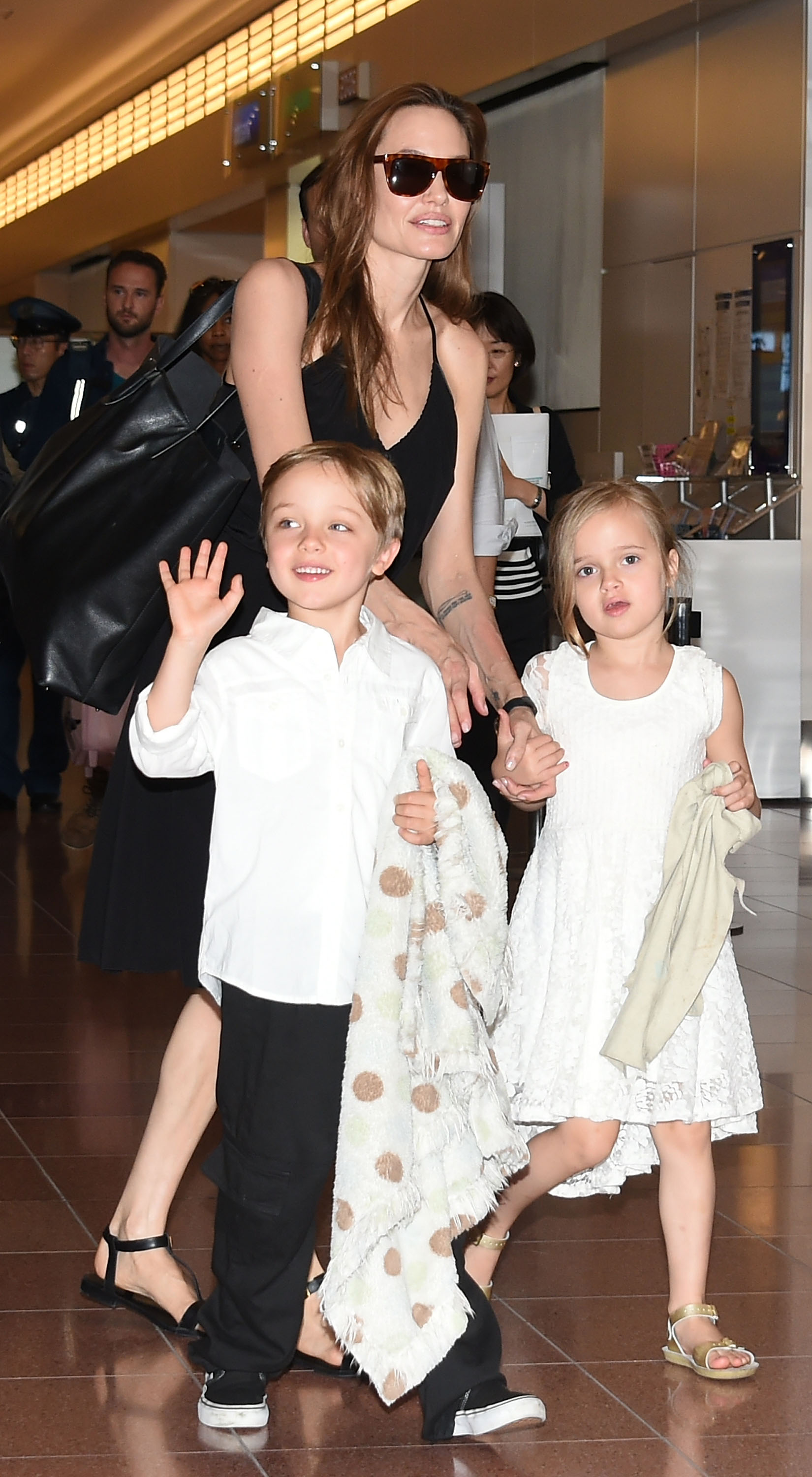 Angelina y Vivienne Jolie con Knox Jolie-Pitt en el aeropuerto de Haneda en Tokio, Japón, el 21 de junio de 2014 | Fuente: Getty Images