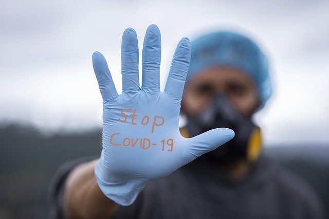 Trabajador de salud con mensaje de "alto al COVID-19" en su guante. | Foto: Pixabay