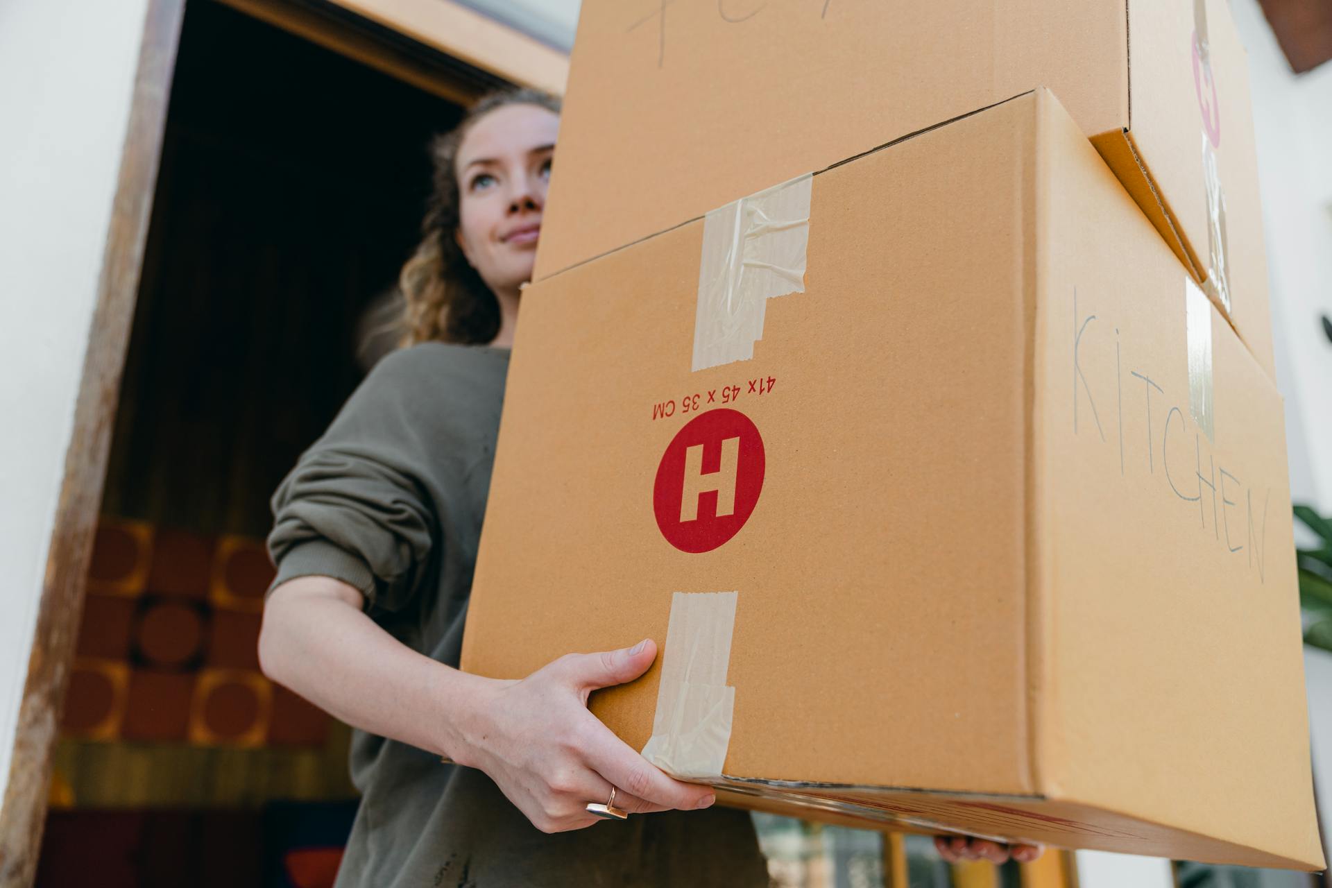 Una joven cargando cajas de cartón | Fuente: Pexels