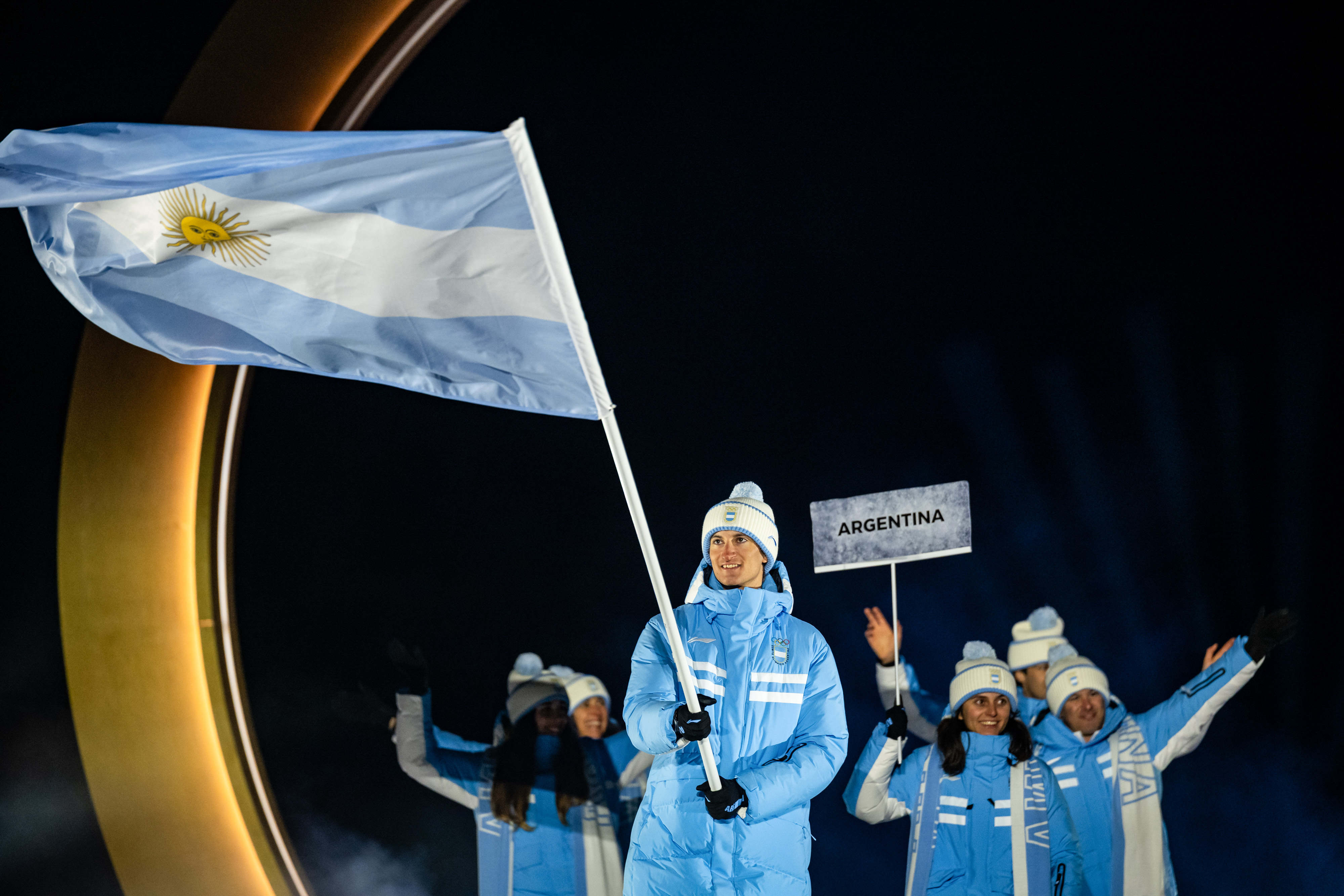 Franco Dal Farra, del equipo argentino, y otros miembros del equipo ingresan al estadio durante la ceremonia inaugural de los Juegos Olímpicos de Invierno Milano Cortina 2026 en el Estadio de Salto de Esquí Predazzo, el 6 de febrero de 2026 en Val di Fiemme, Italia. | Fuente: Getty Images
