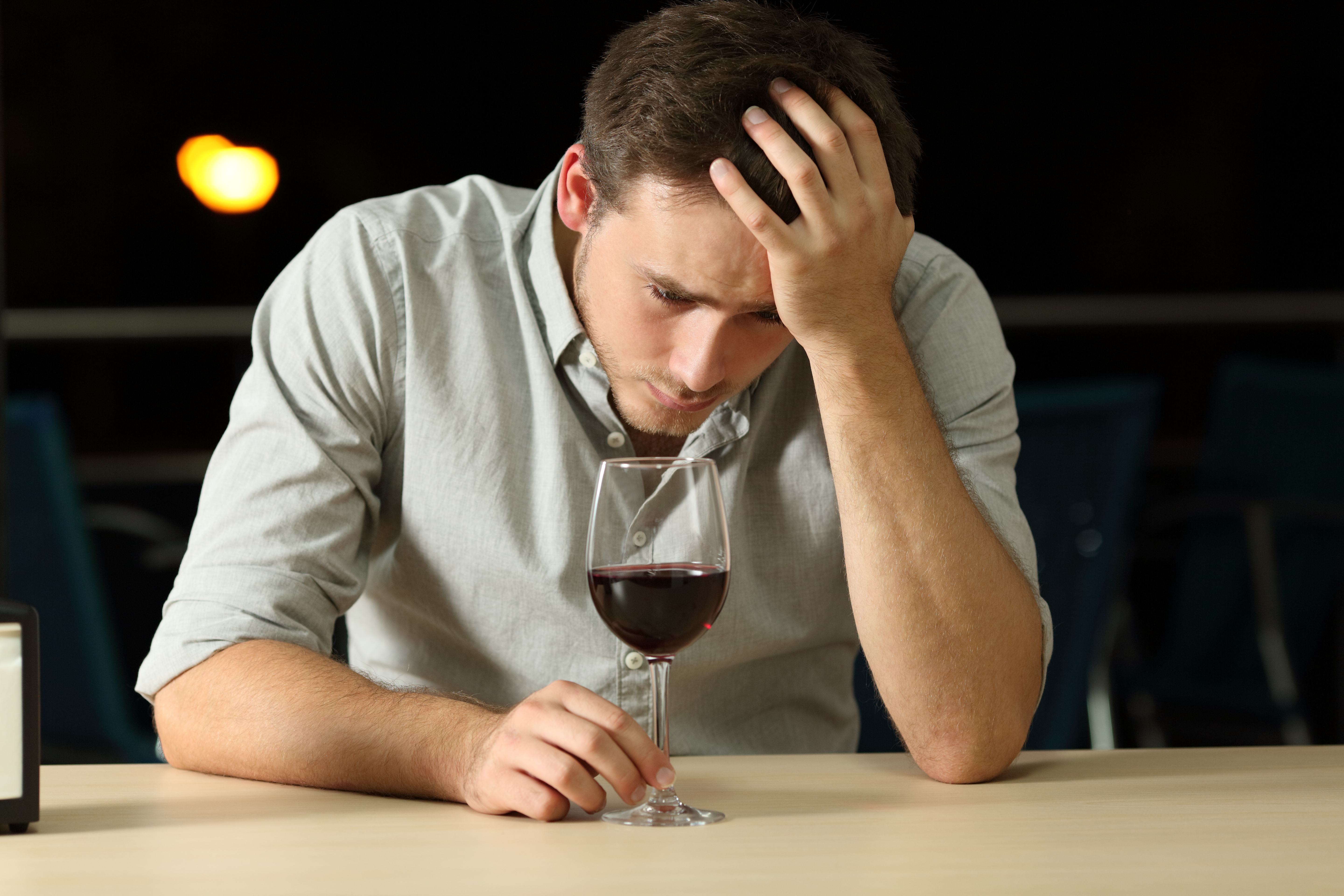 Hombre triste sentado solo con una bebida | Foto: Shutterstock