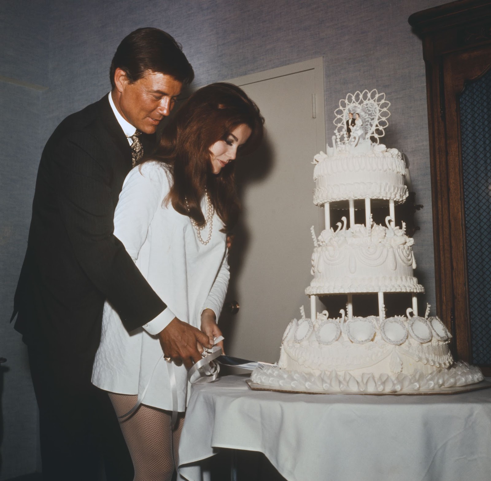 La actriz de origen sueco y Roger Smith cortando su pastel de bodas tras su ceremonia nupcial en el Hotel Riviera de Las Vegas, el 8 de mayo de 1967 | Fuente: Getty Images