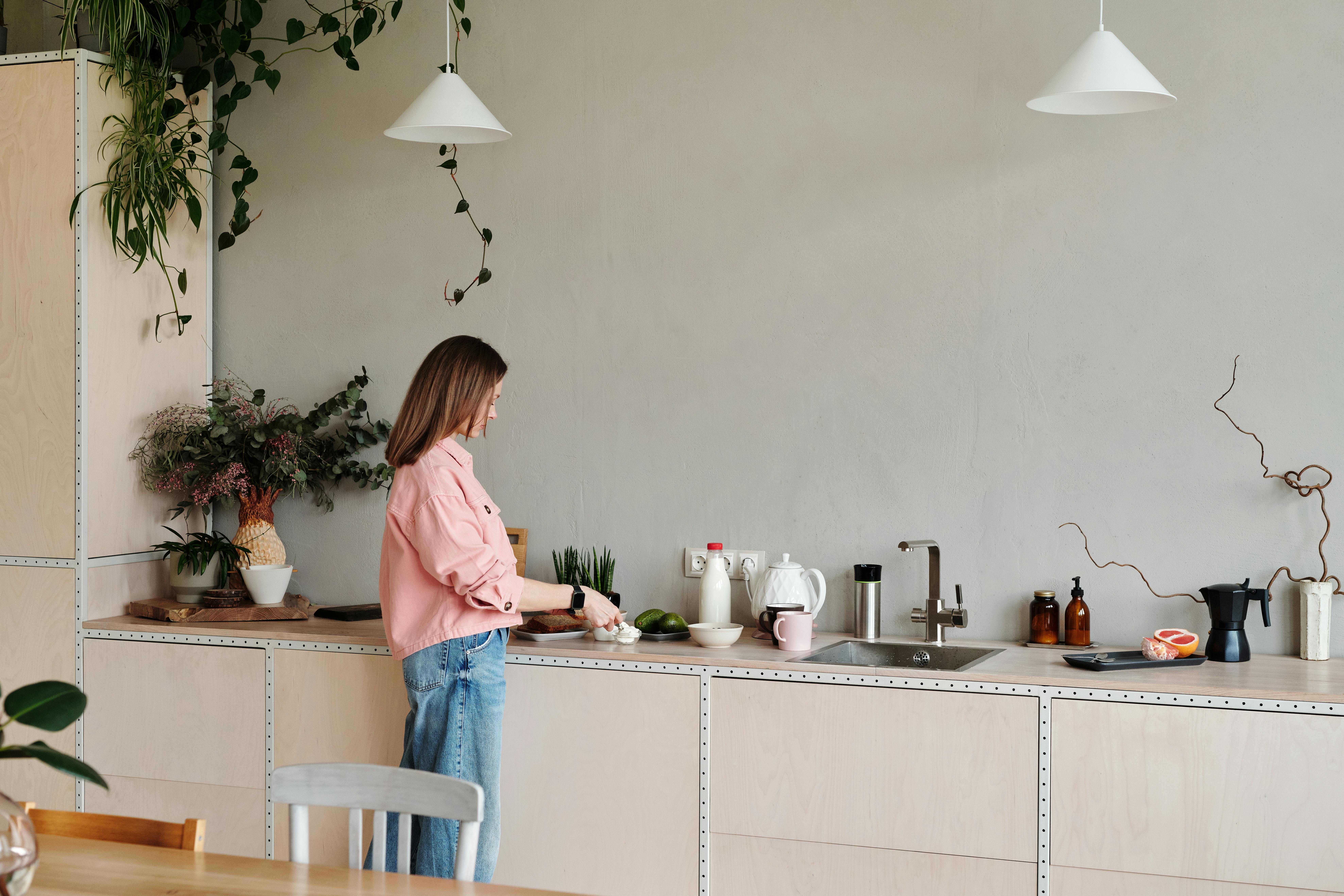 Una mujer de pie en su cocina | Fuente: Pexels
