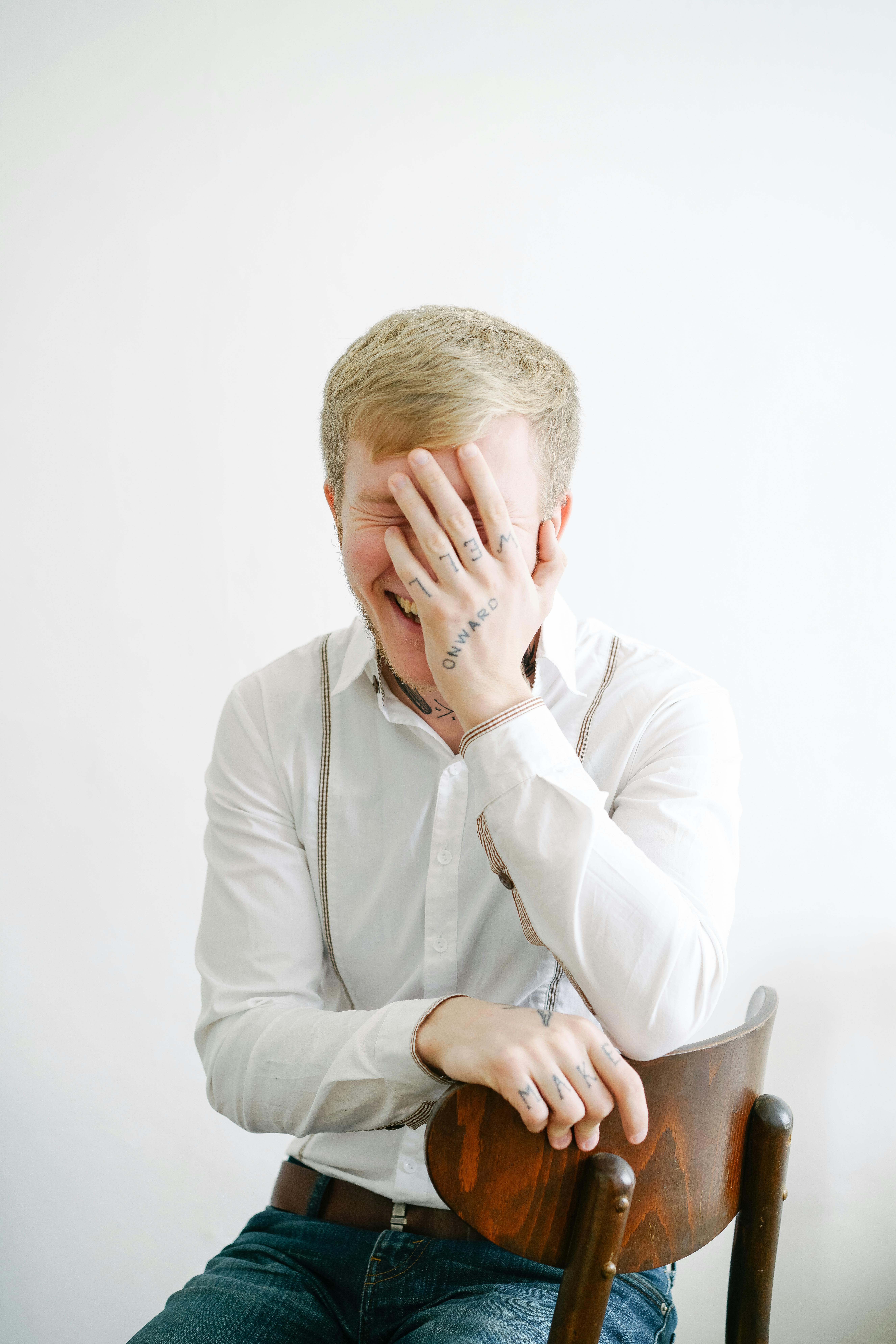 Un hombre sentado en una silla riendo | Fuente: Pexels