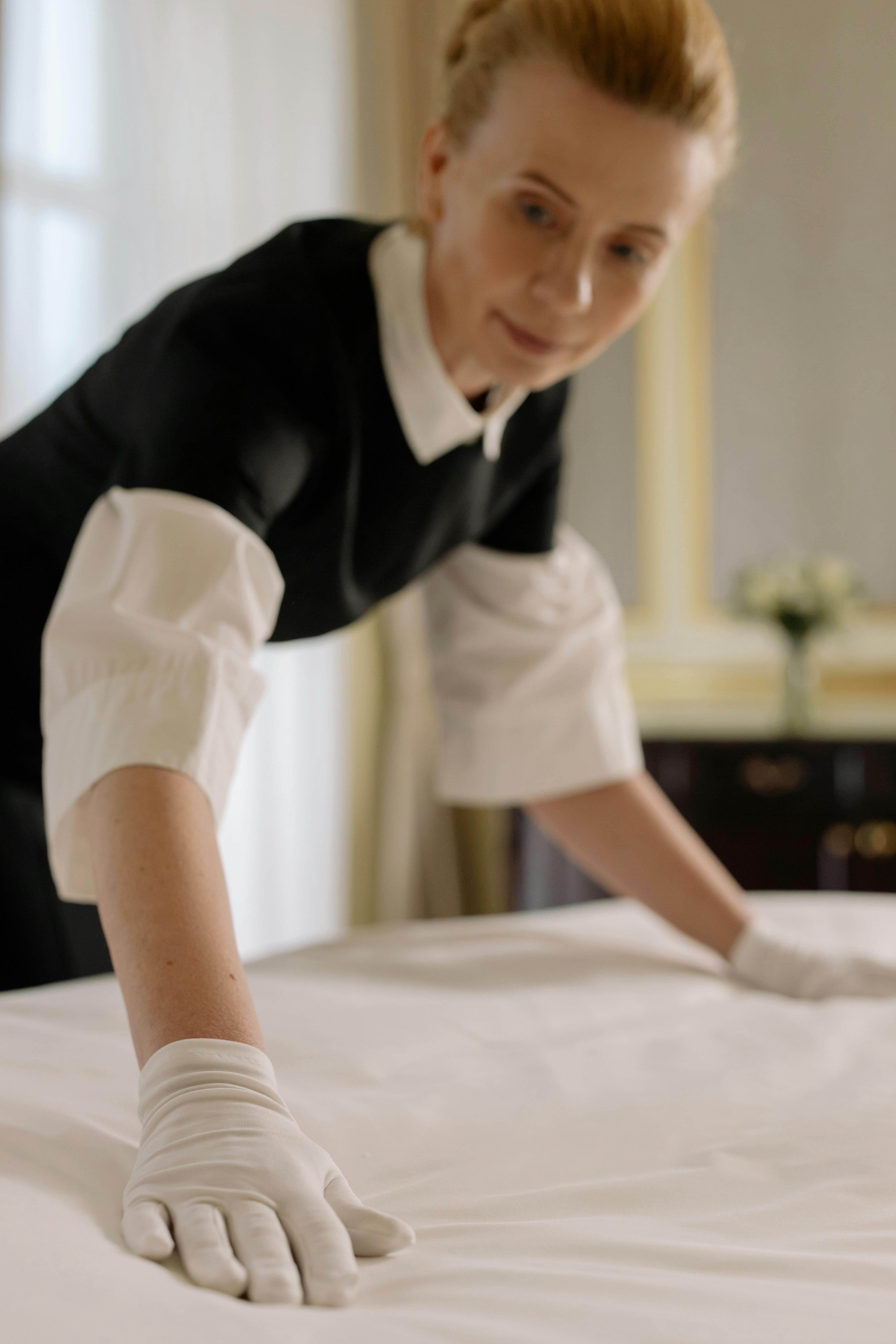 Mujer arreglando una habitación de hotel | Fuente: Pexels