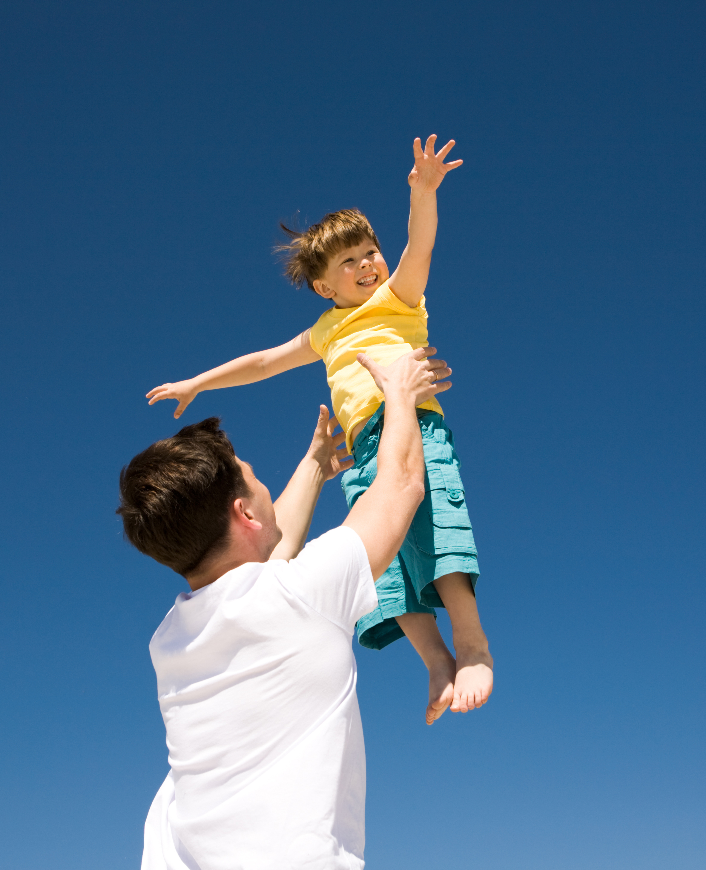 Un hombre jugando con un niño al aire libre | Fuente: Shutterstock