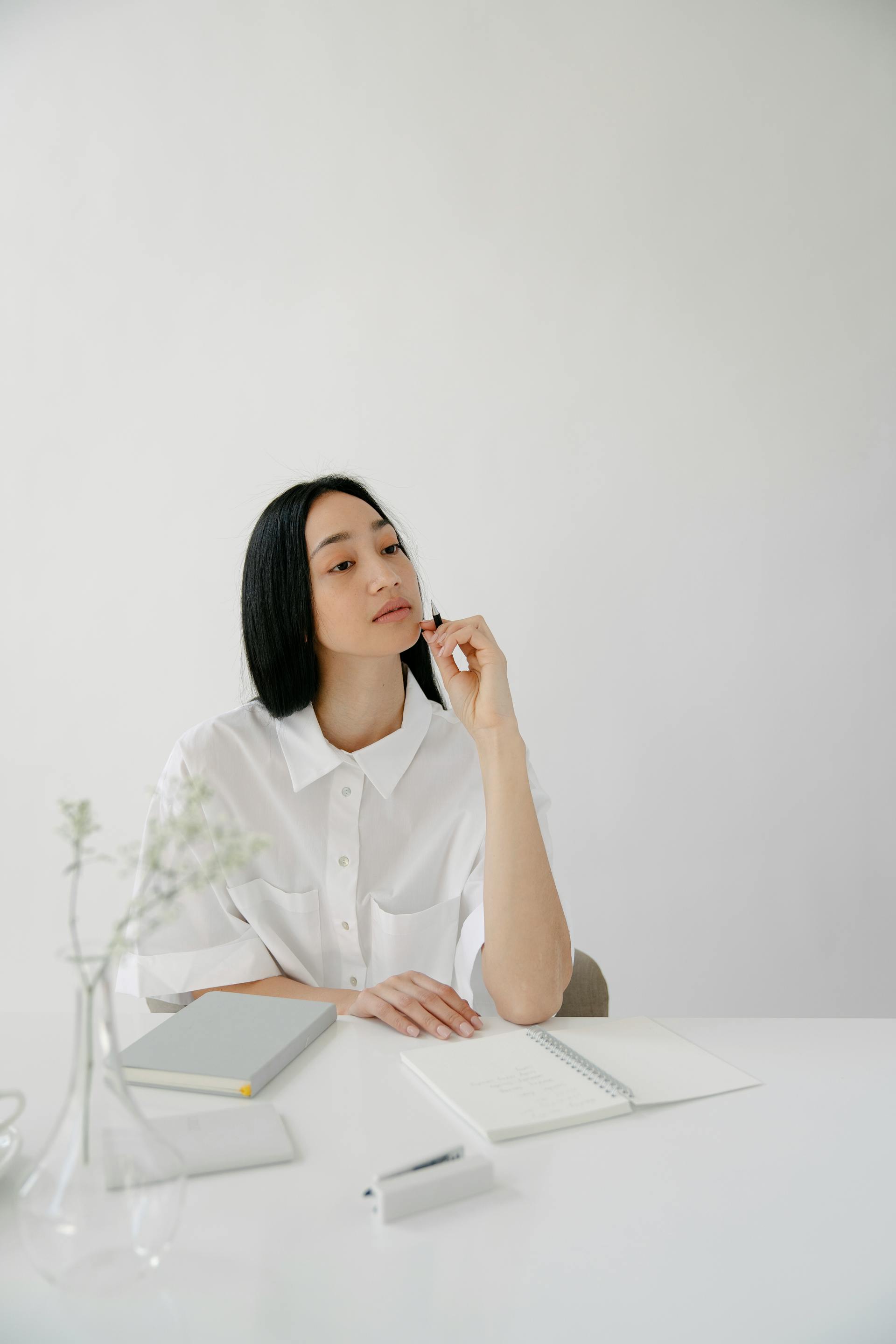 Una mujer en un escritorio mirando por debajo de su nariz | Fuente: Pexels