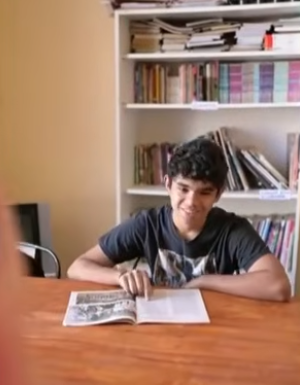 Lucio sonrie mientras lee una revista | Fuente: YouTube/eltrece