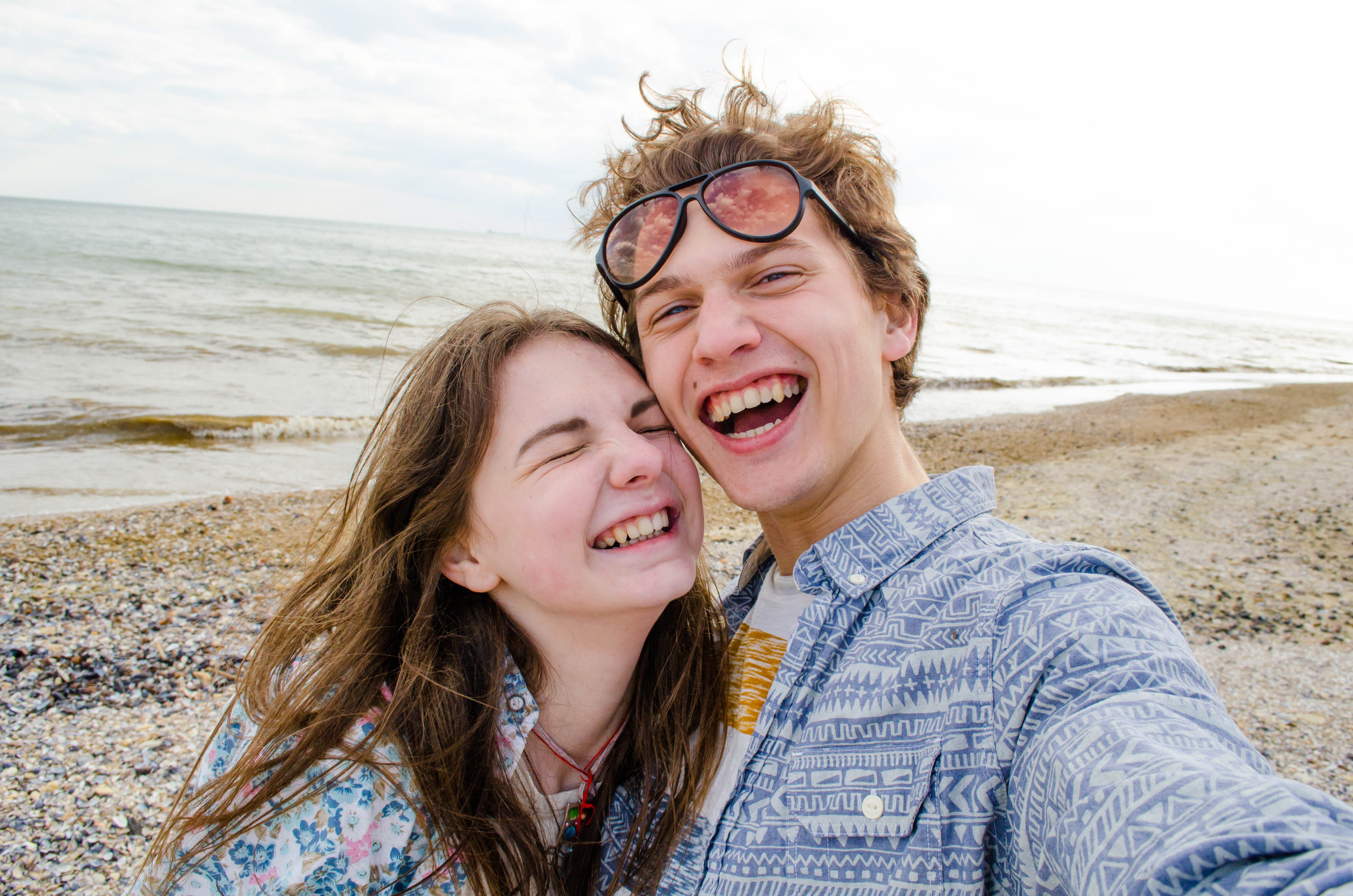 Una joven pareja tomándose un selfie en la playa. | Foto: Shutterstock