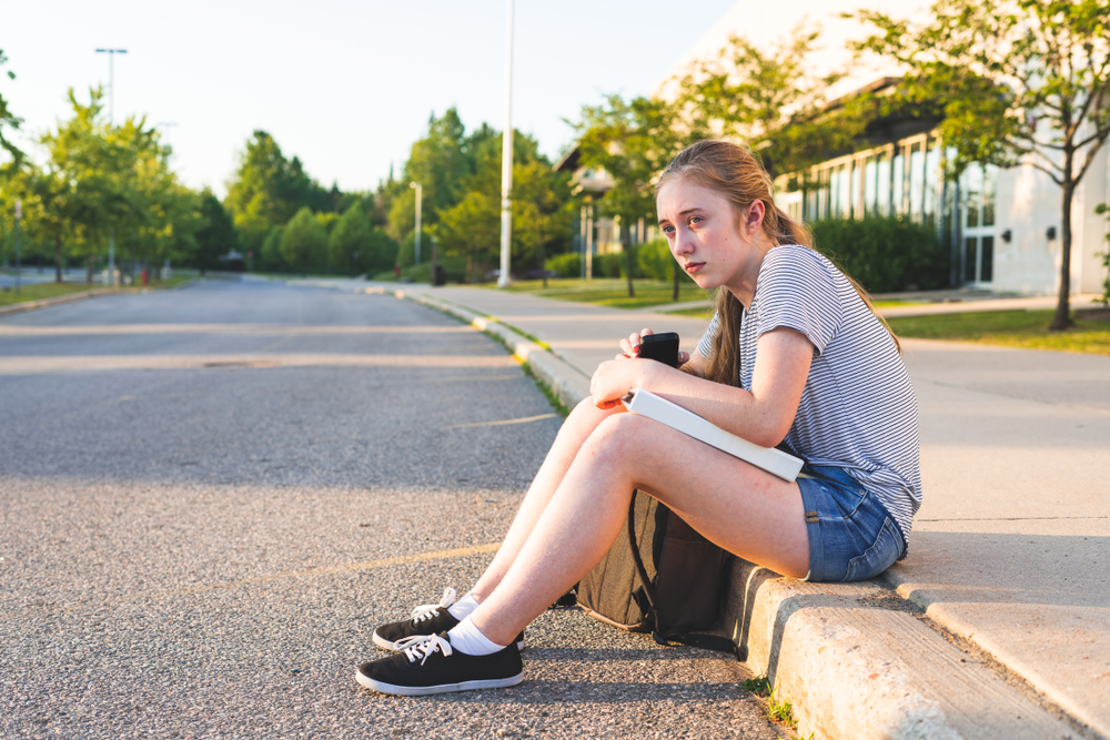 Una joven sentada junto a una carretera | Foto: Shutterstock