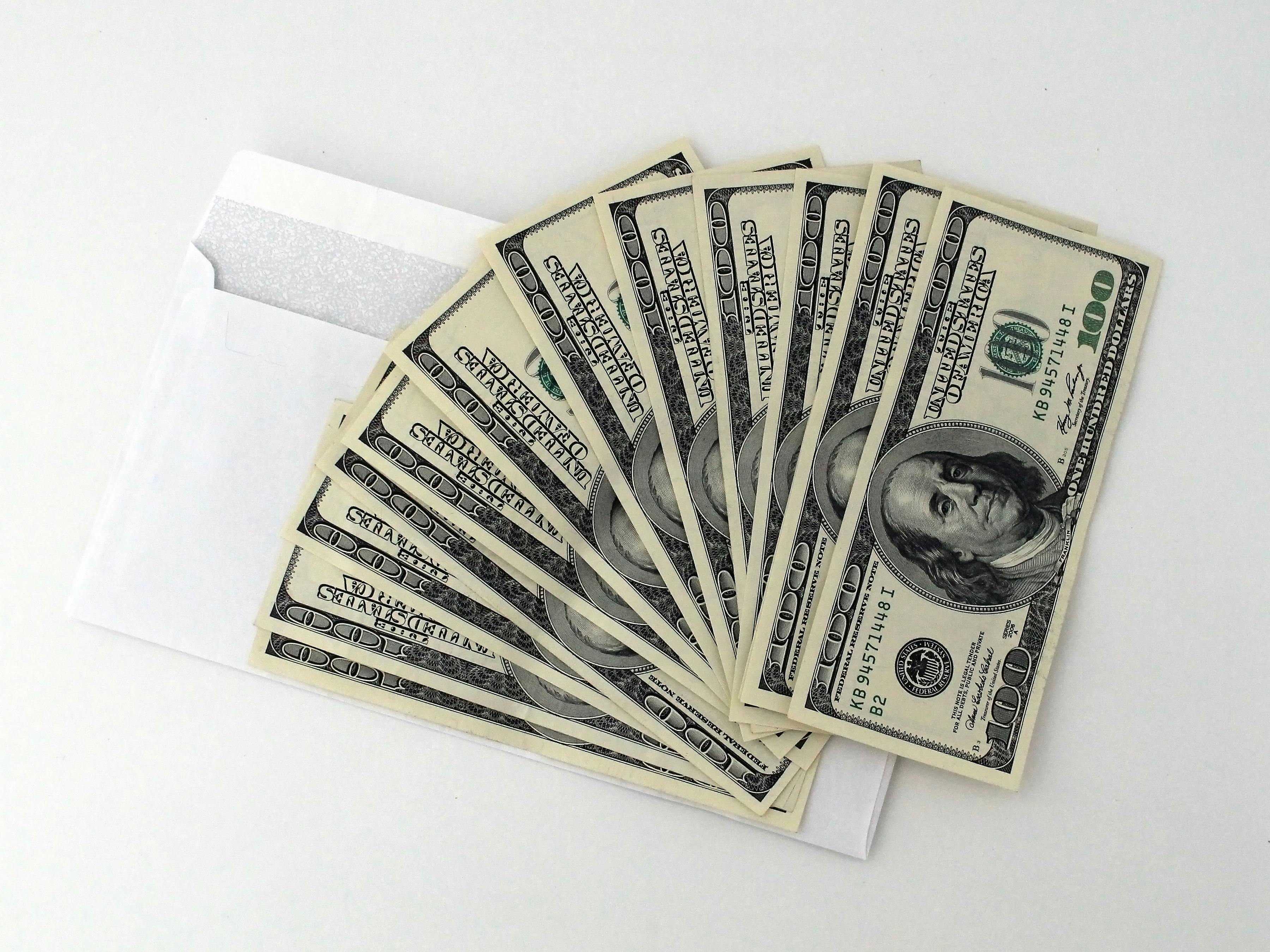 Varios billetes de dólar colocados en un sobre | Fuente: Pexels
