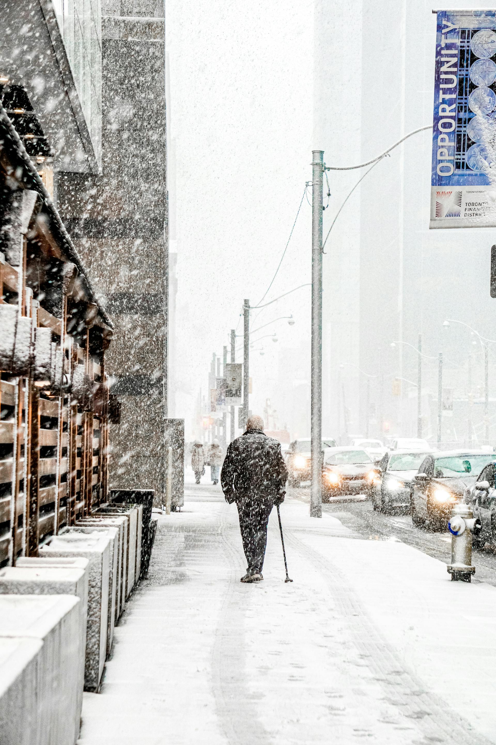 Vista trasera de un anciano caminando por una acera nevada | Fuente: Pexels