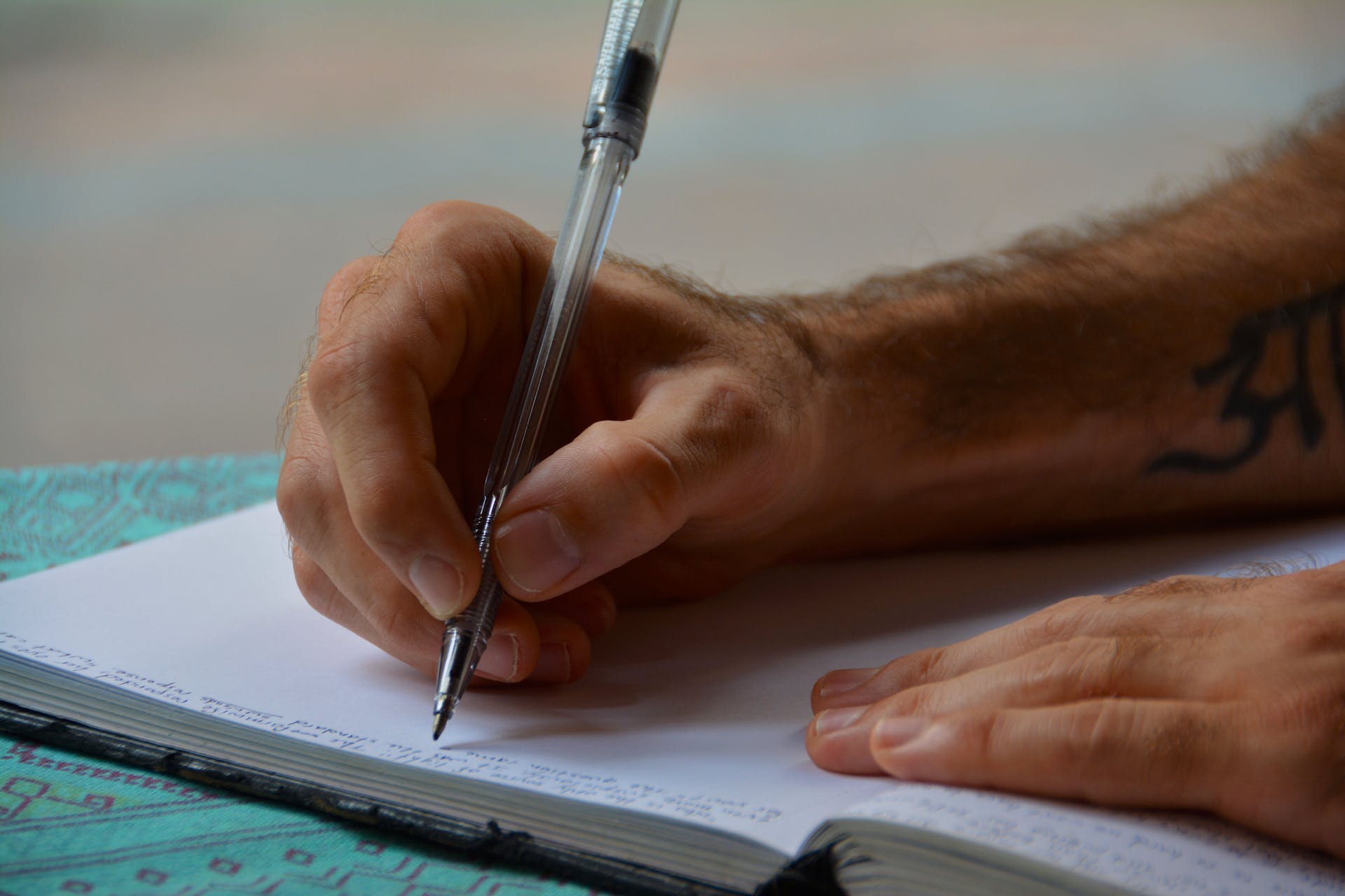 Hombre escribiendo en un cuaderno | Foto: Pexels